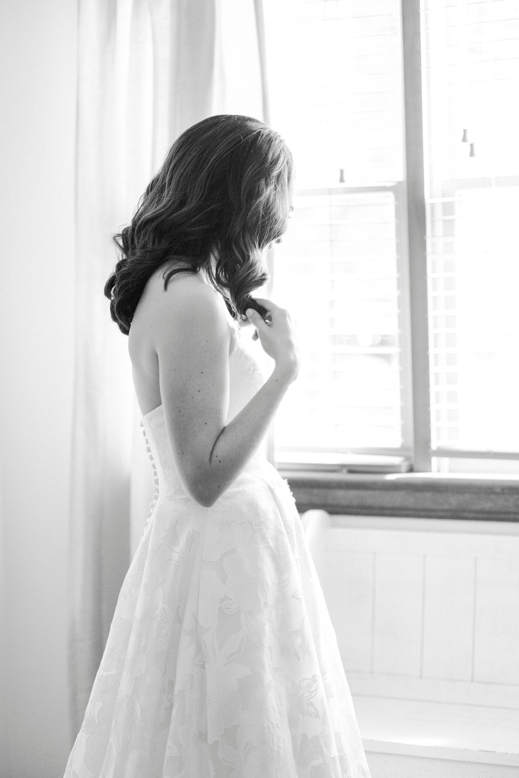 bride looks out the window of suite at Alexander Homestead