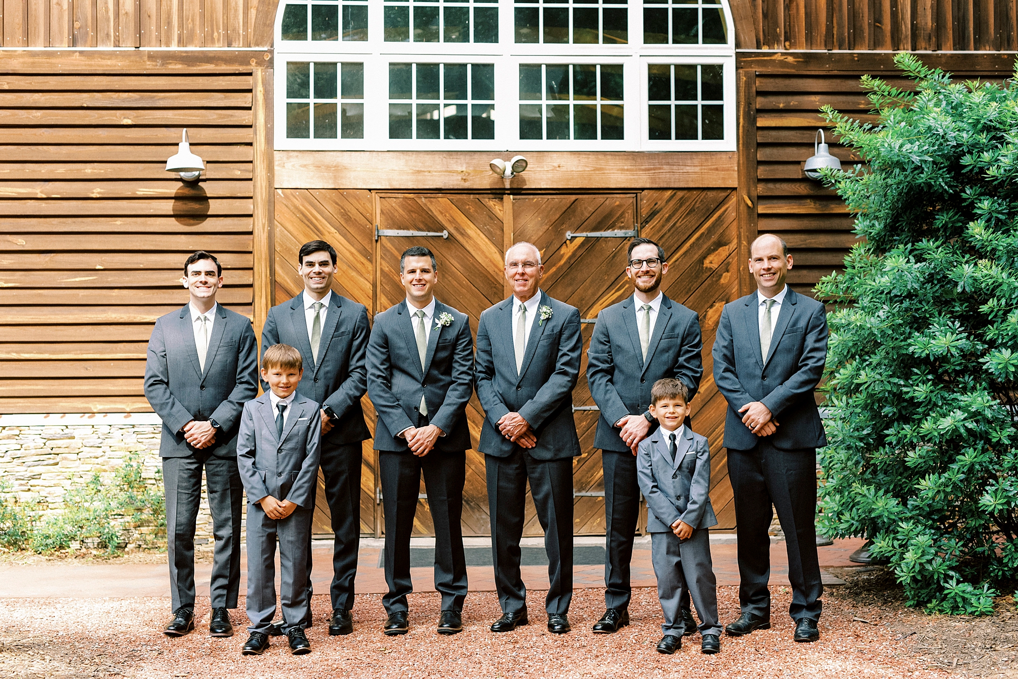 groom stands with groomsmen in a line in blue suits