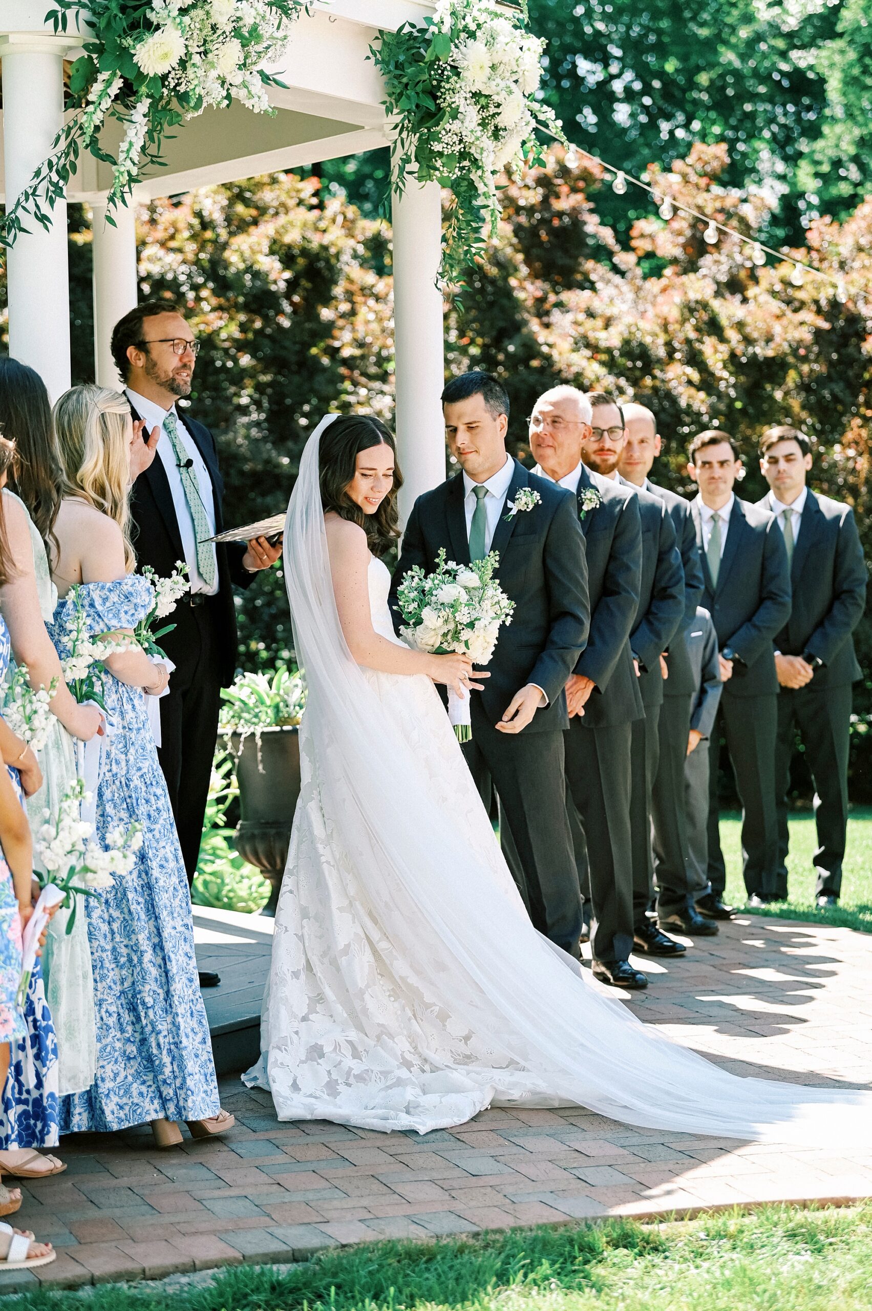 newlyweds smile at guests in gardens of Alexander Homestead