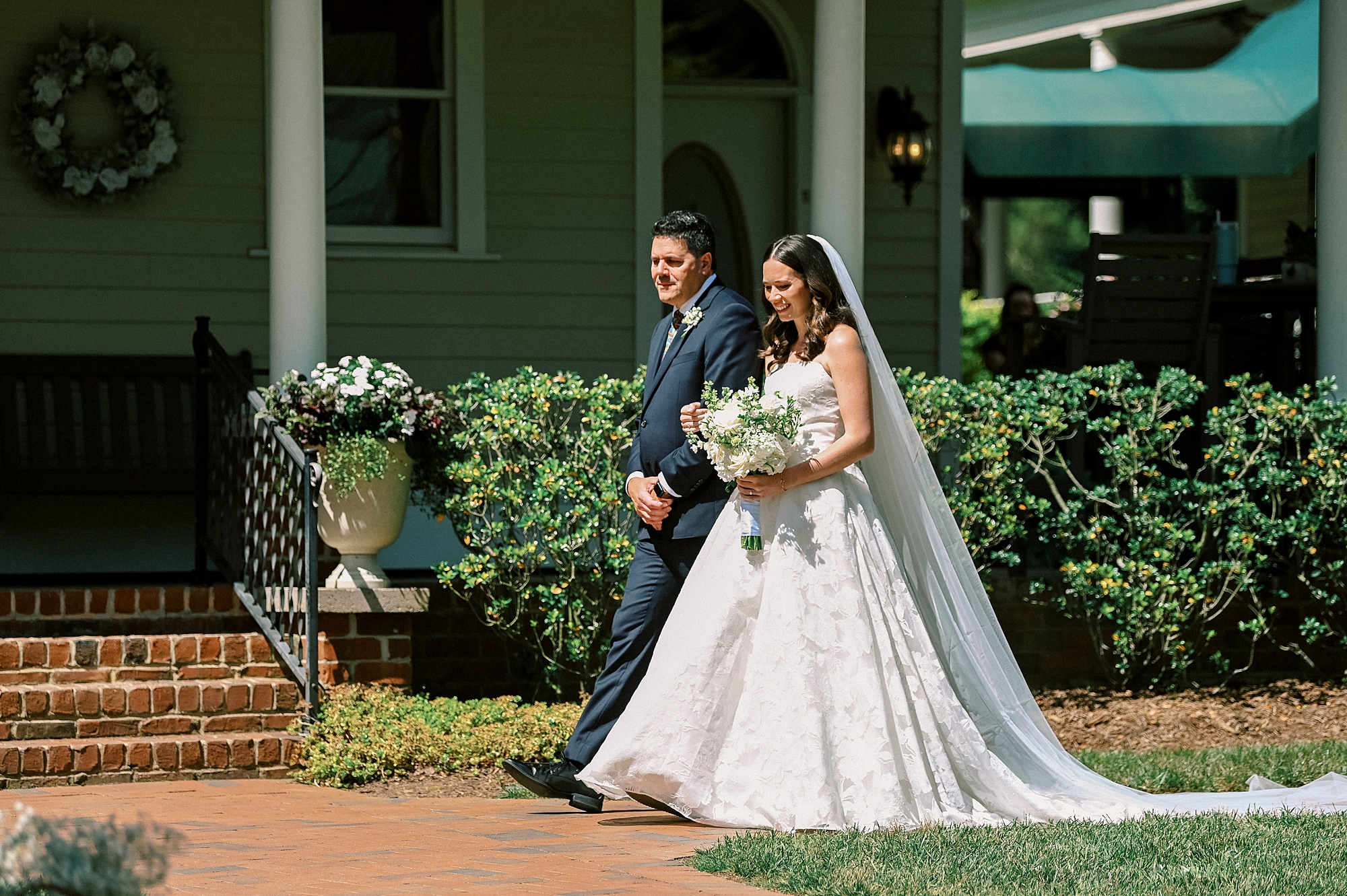 father escorts bride to ceremony in gardens of Kate Edri