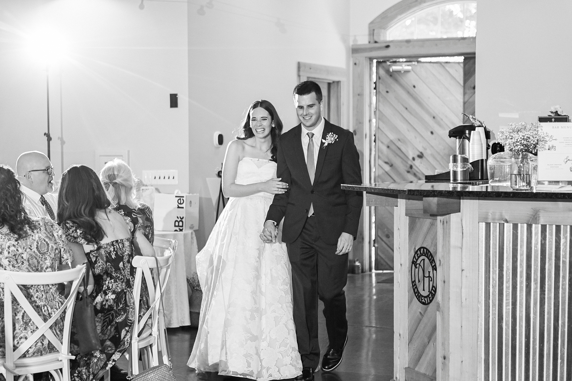 bride and groom hold hands walking into reception at Alexander Homestead barn