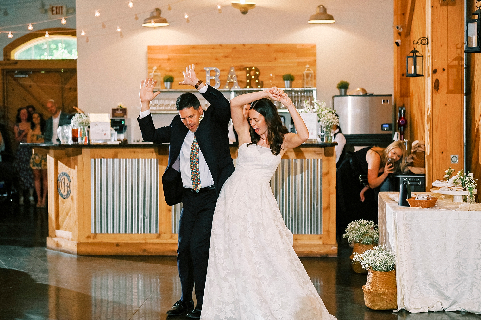 bride and dad bump hips during dance at reception