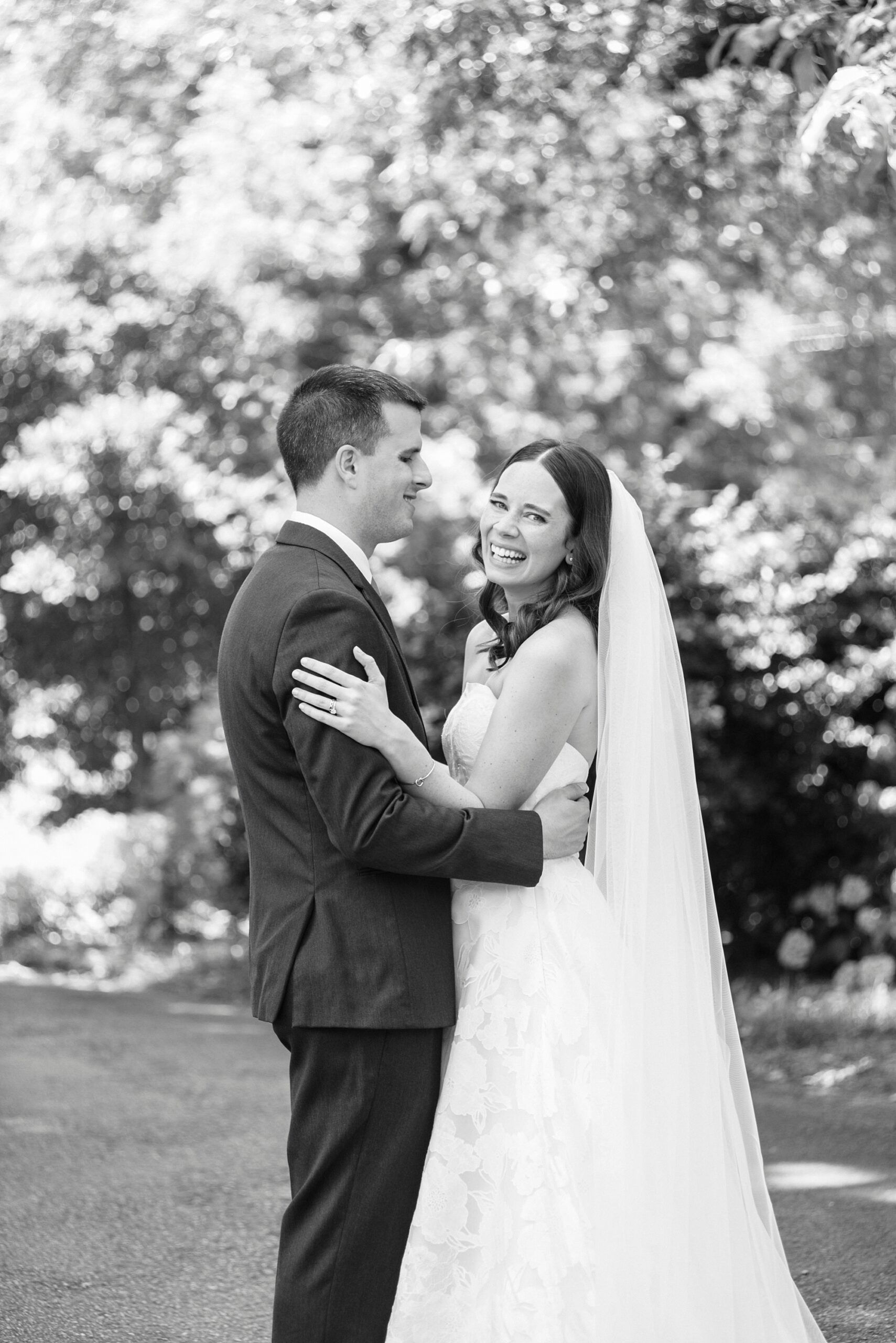 newlyweds smile hugging each other in gardens of Alexander Homestead