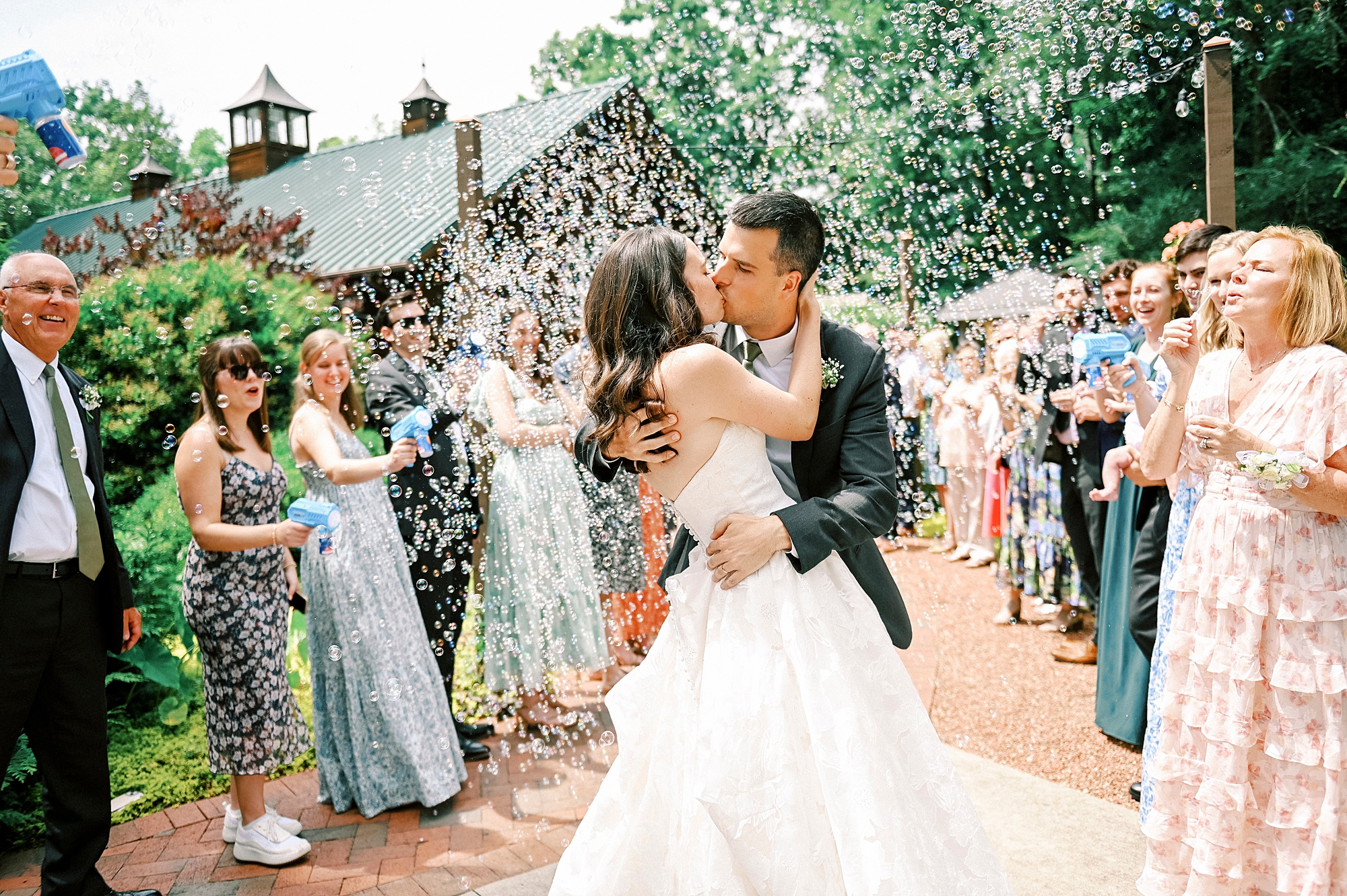 newlyweds kiss during bubble exit from reception at Alexander Homestead
