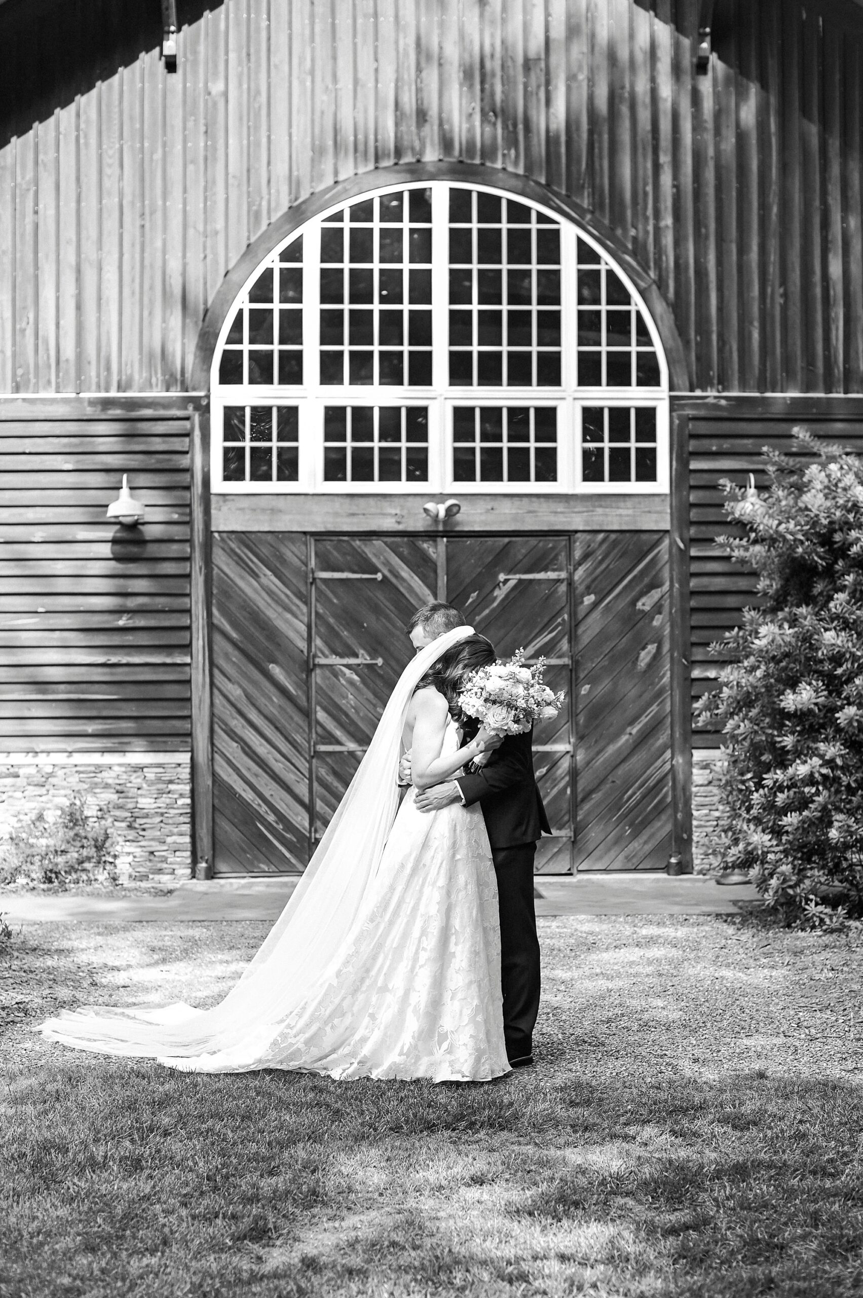 newlyweds kiss outside wooden door at Alexander Homestead
