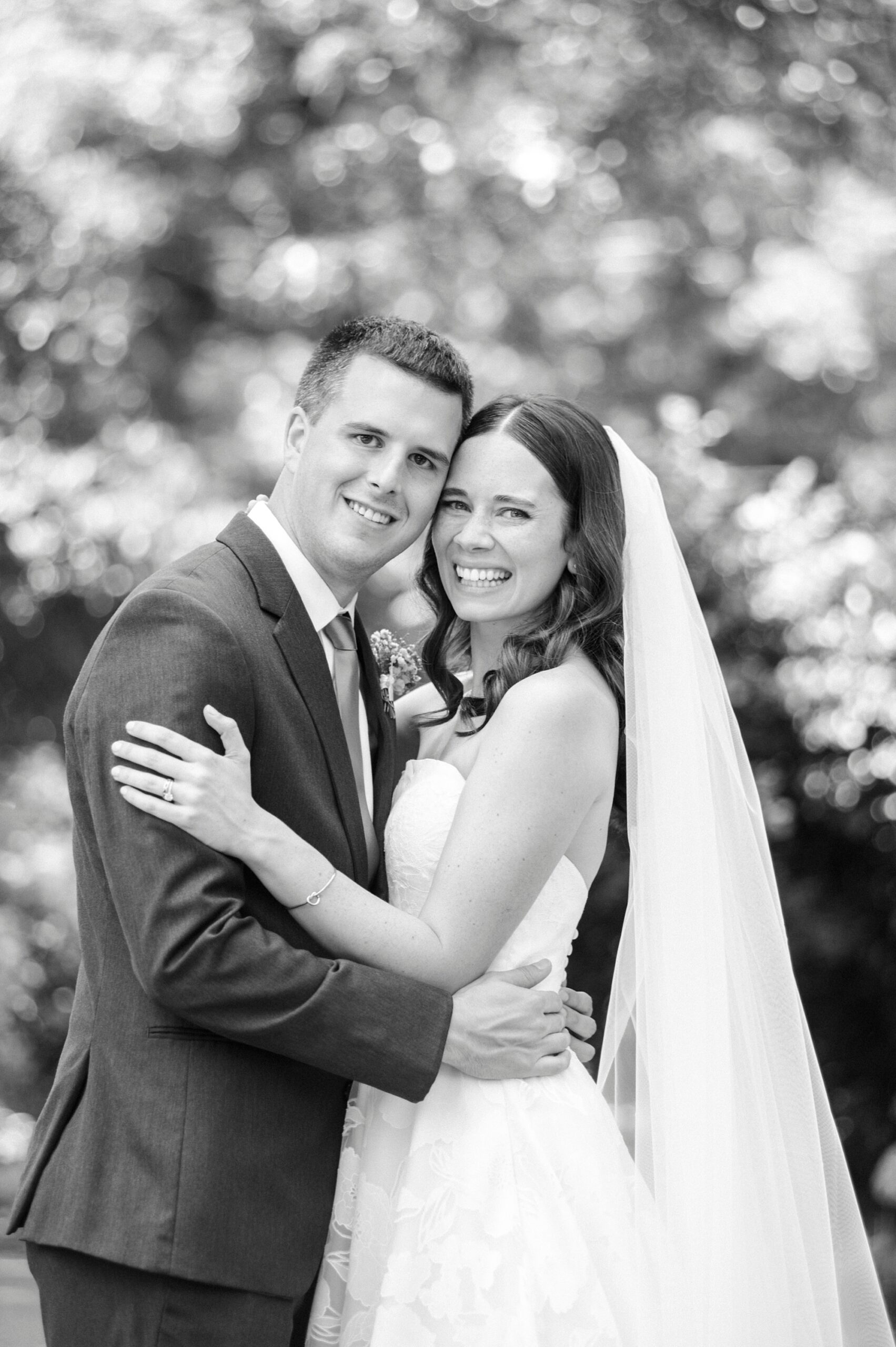 bride and groom hug leaning heads together in gardens at Alexander Homestead