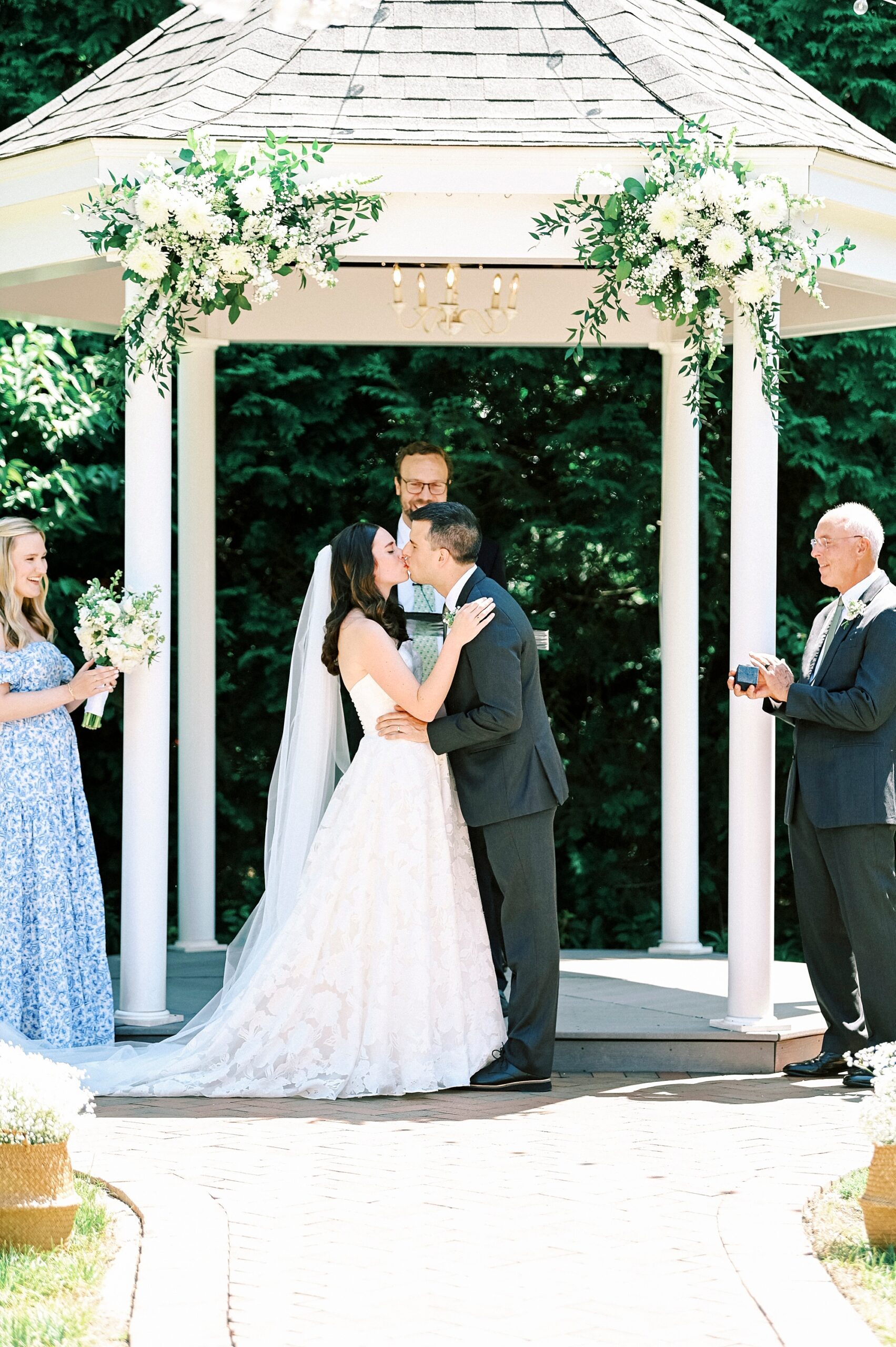 newlyweds kiss in gazebo at Alexander Homestead during ceremony