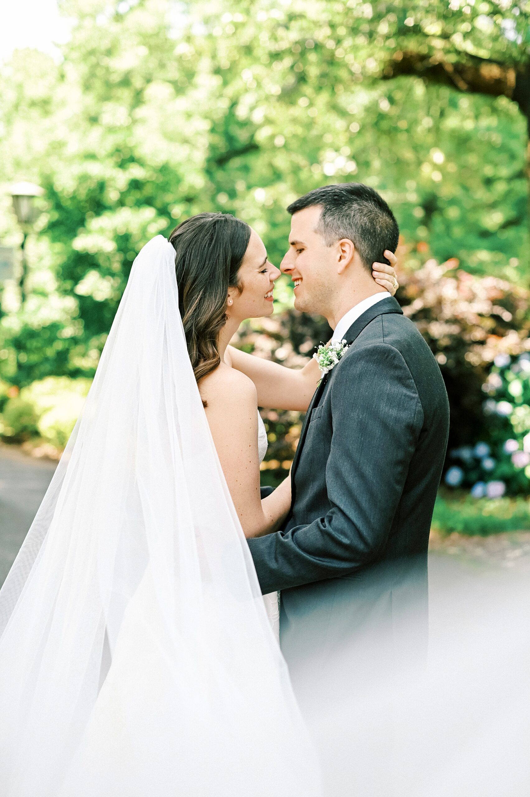 bride holds groom's head and leans to kiss him on wedding day