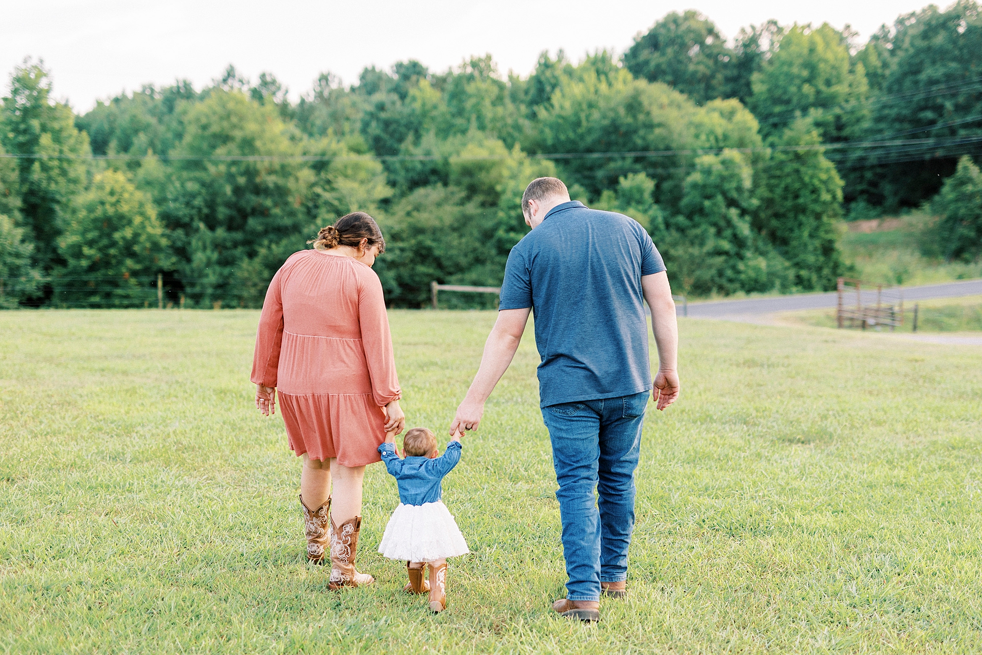 parents walk with one year old across Albemarle NC farm