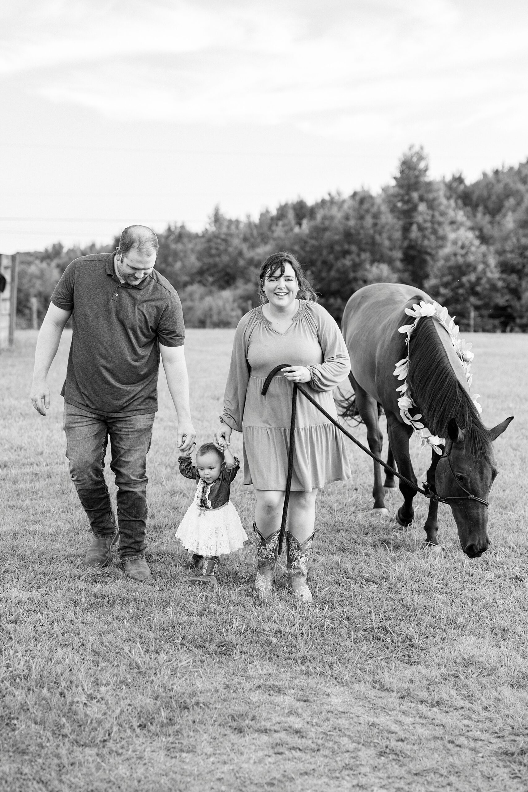 parents walk with daughter and horse behind them