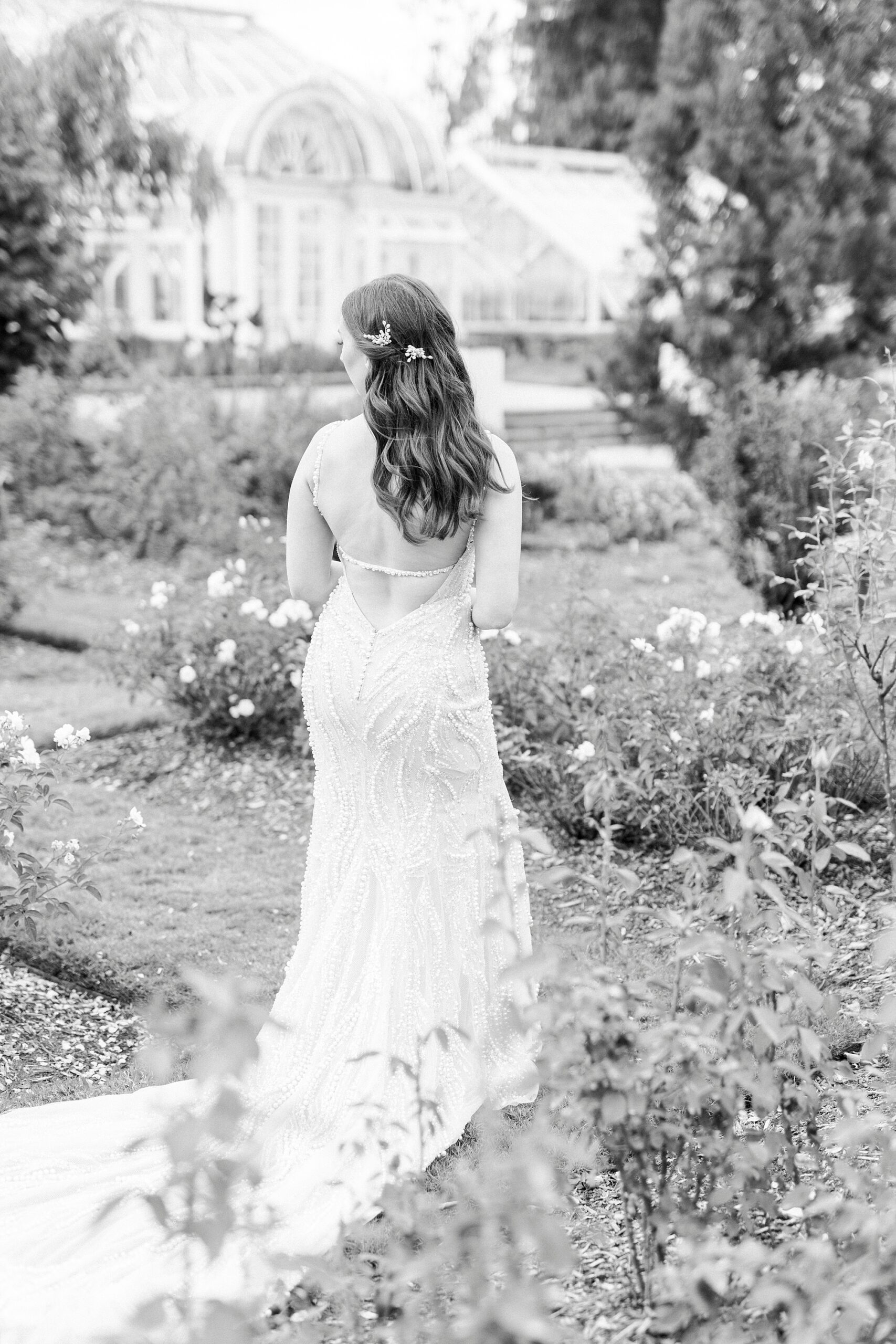 black and white portrait of bride walking through Reynolda Gardens