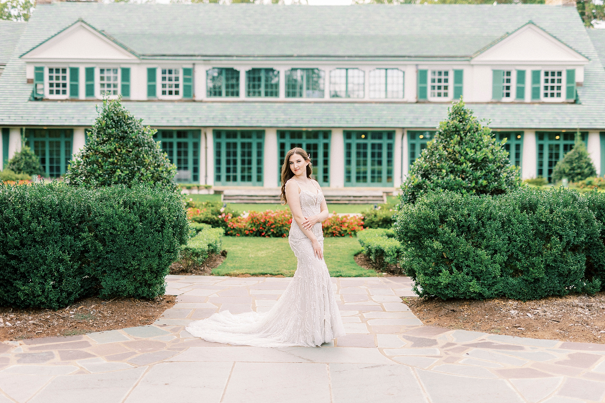 bride stands holding her arm across her stomach outside Reynolda Gardens