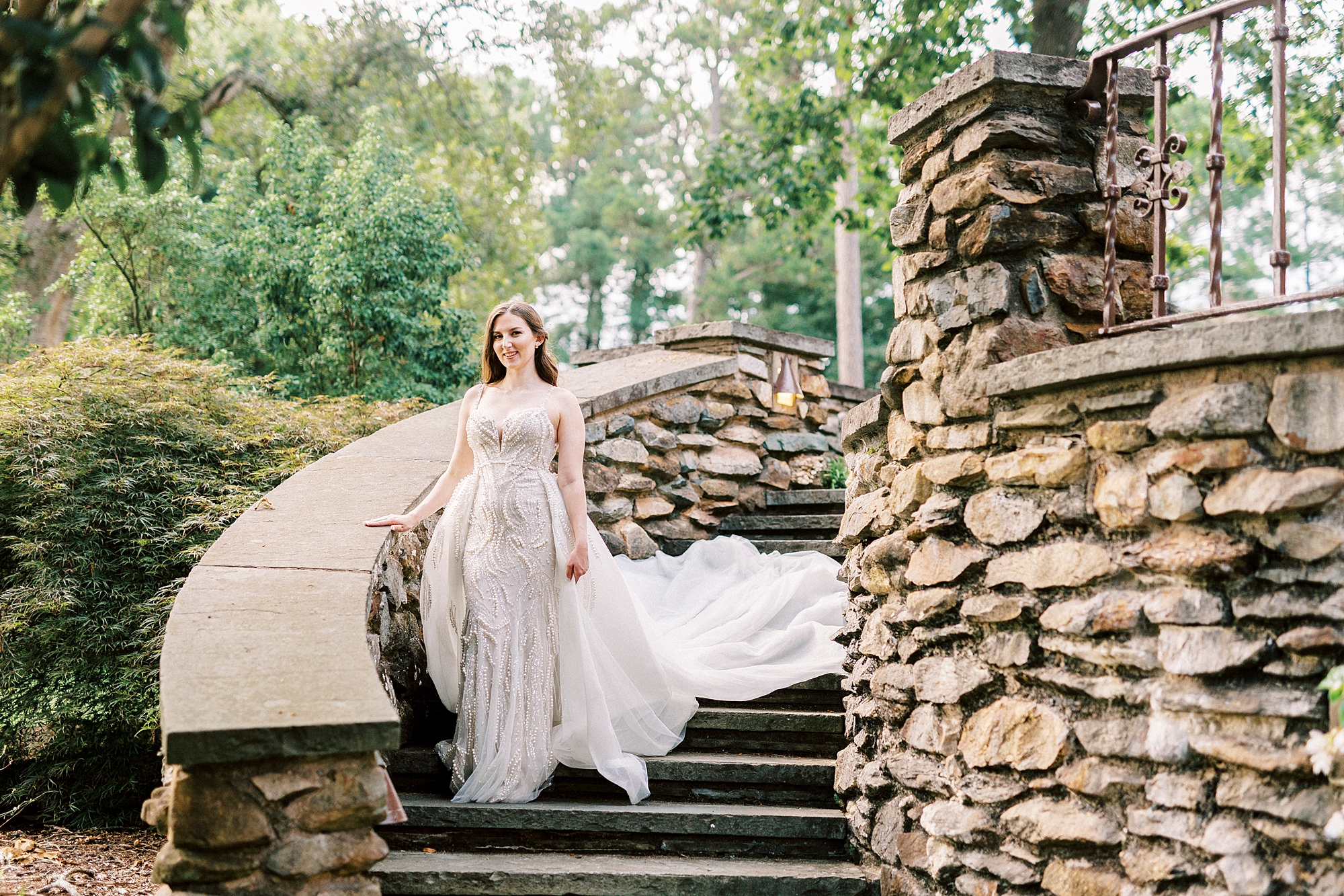 bride walks down stone steps at the Graylyn Estate