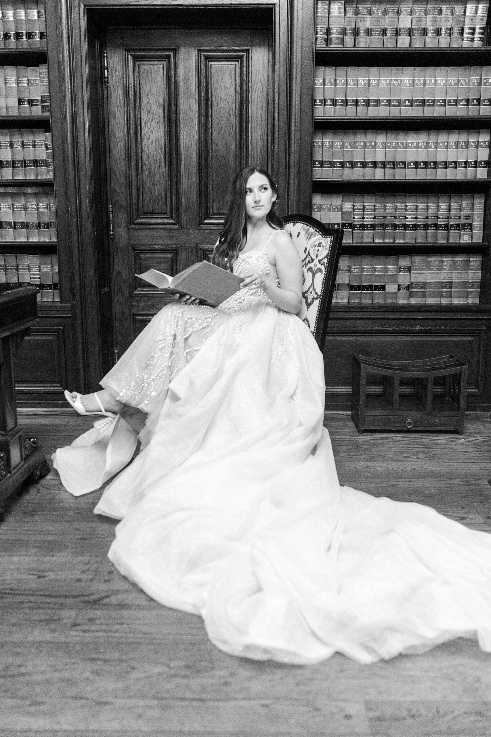 bride sits in front of library books inside the Graylyn Estate