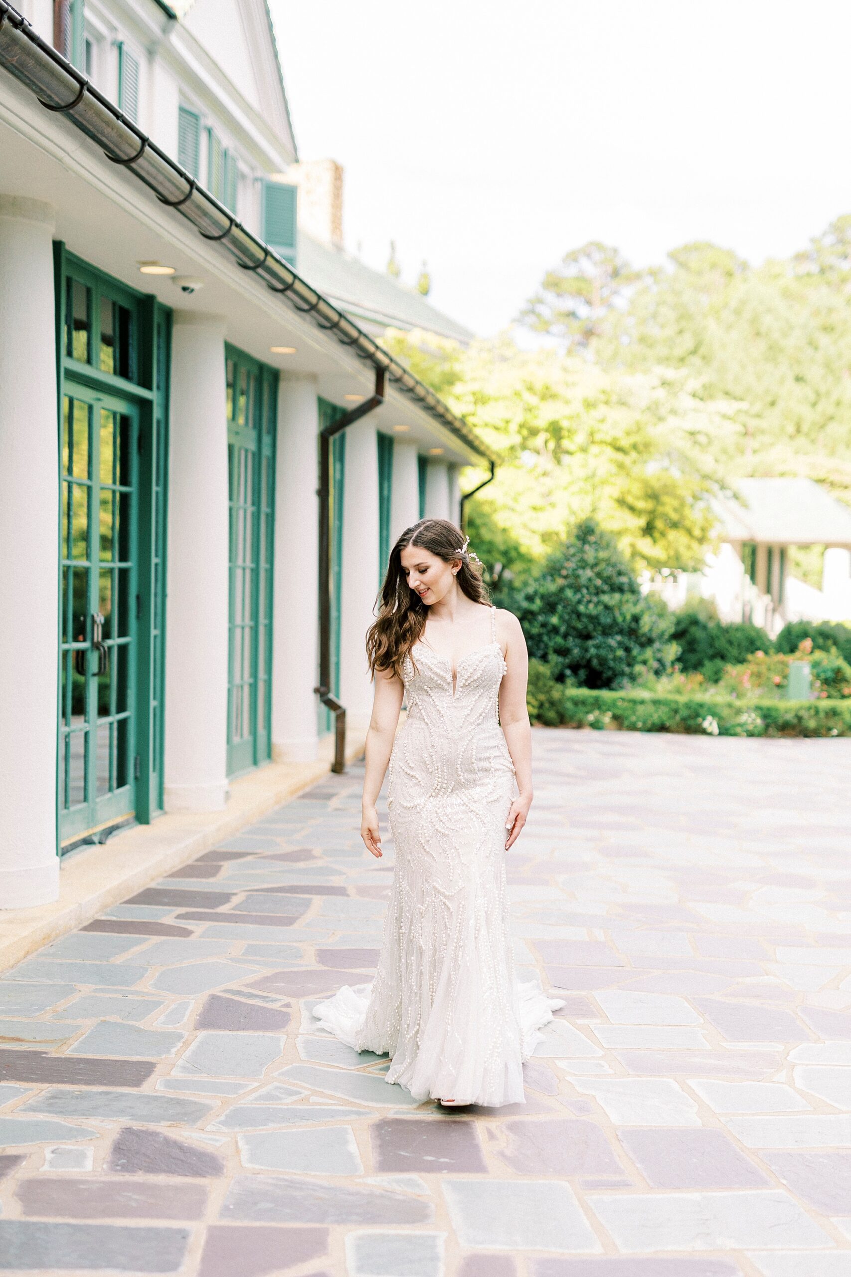 bride walks by green paned windows in North Carolina