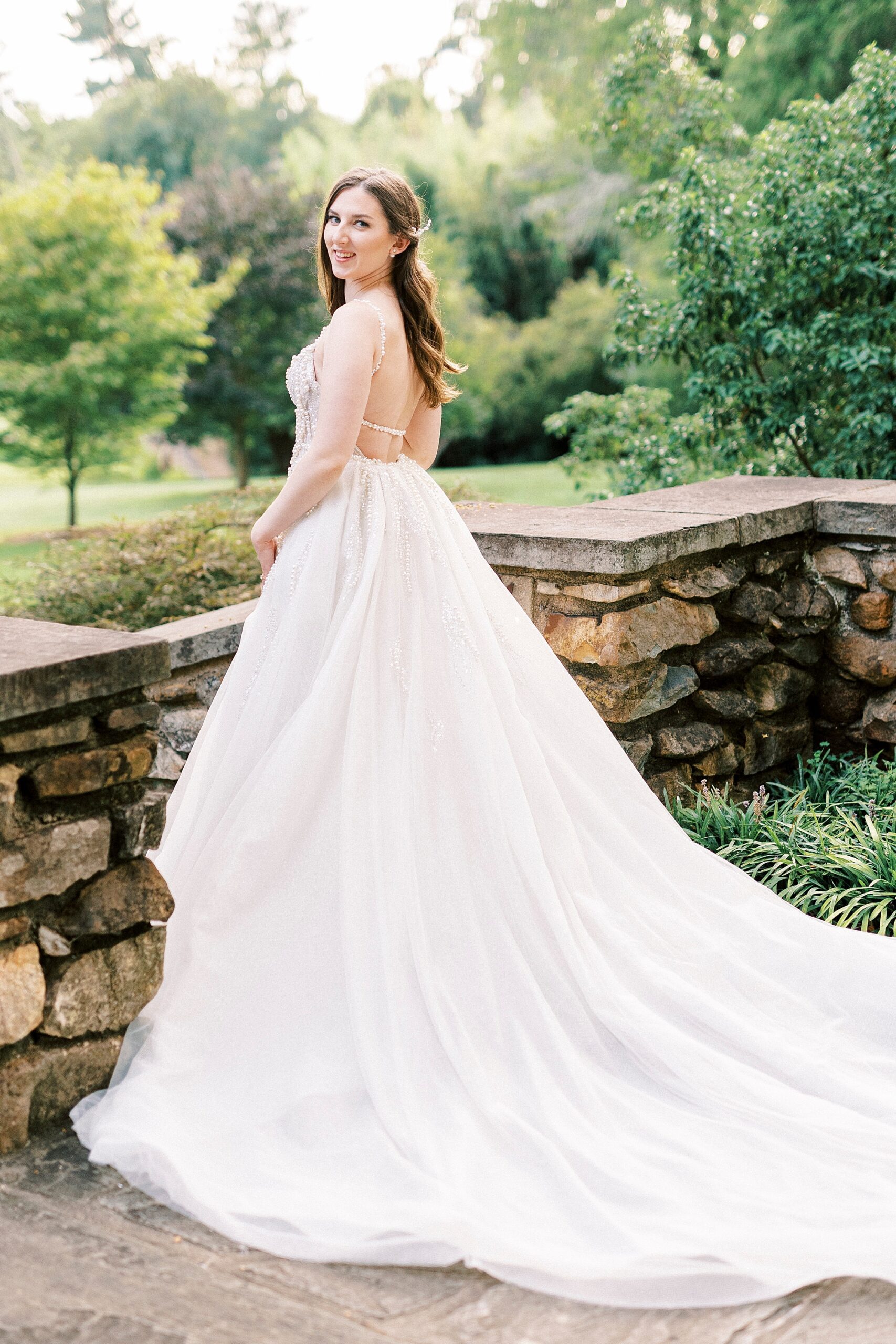 bride stand against railing of the stone patio at the Graylyn Estate