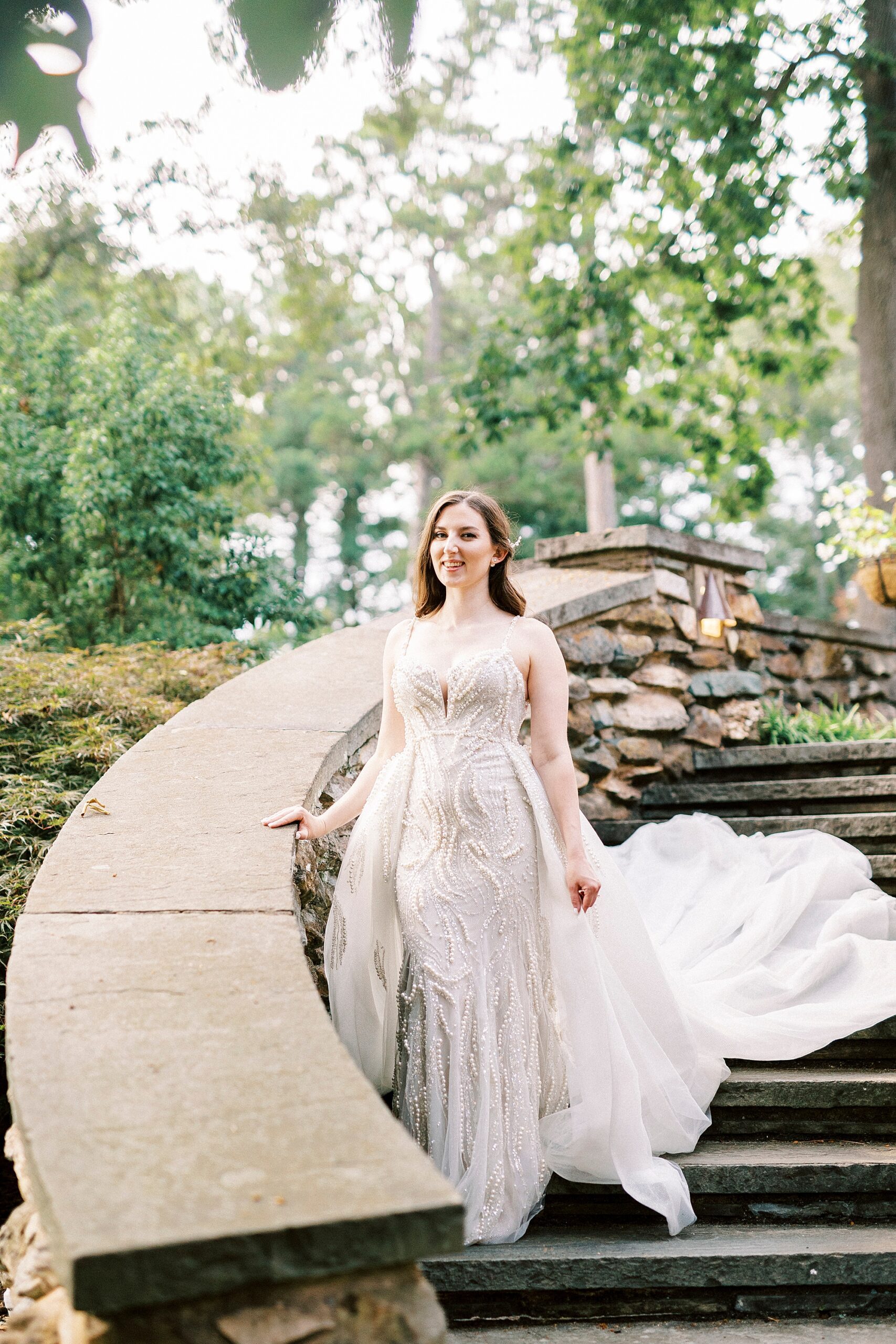 bride lays hand on stone railing of staircase