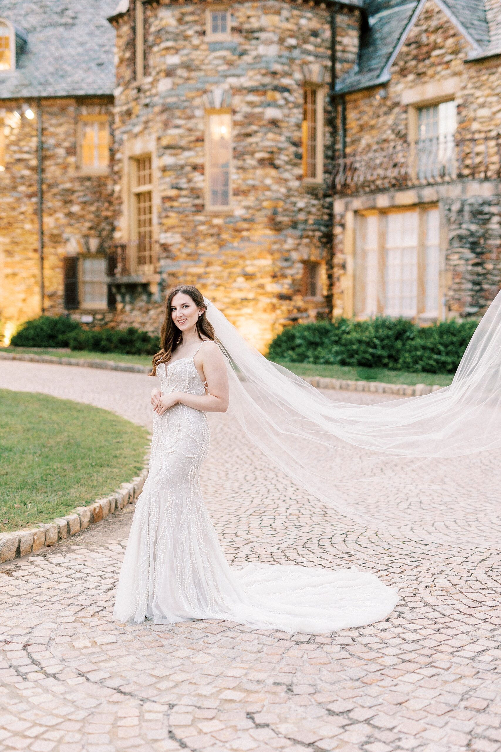 bride stands in front of the the Graylyn Estate lit up