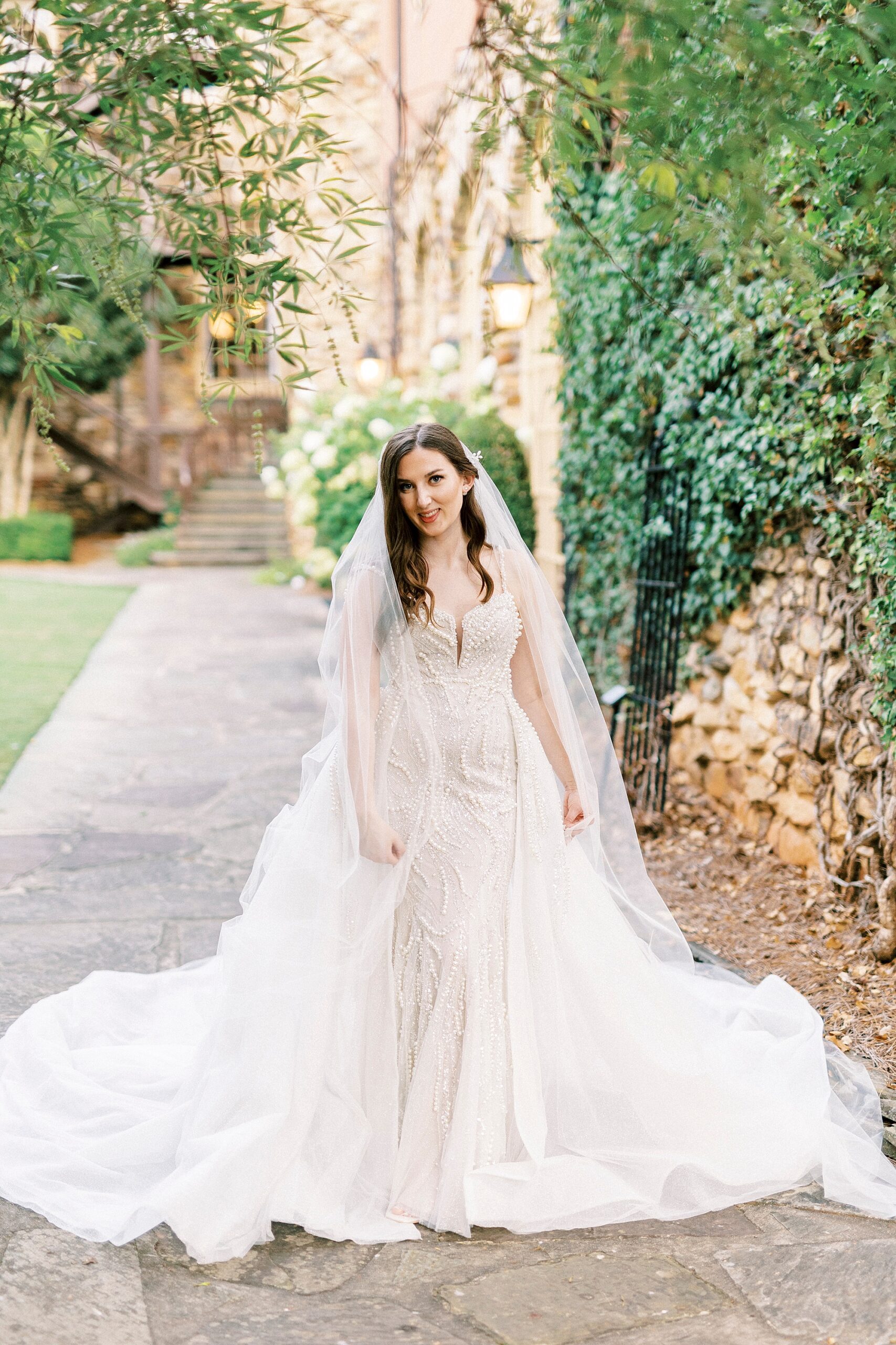 bride smiles pulling veil around her at the Graylyn Estate