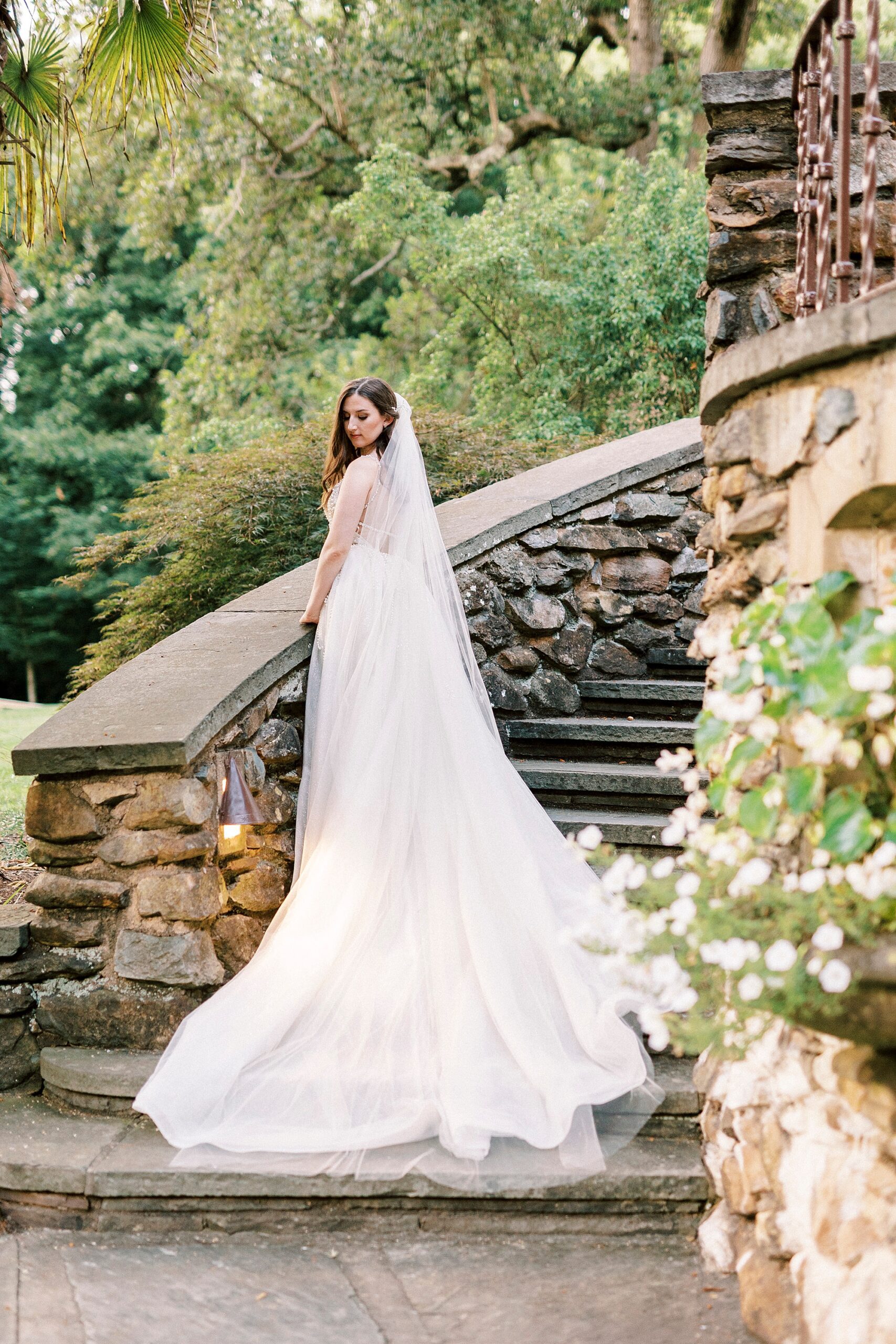 bride stands on the stone staircase outside the Graylyn Estate