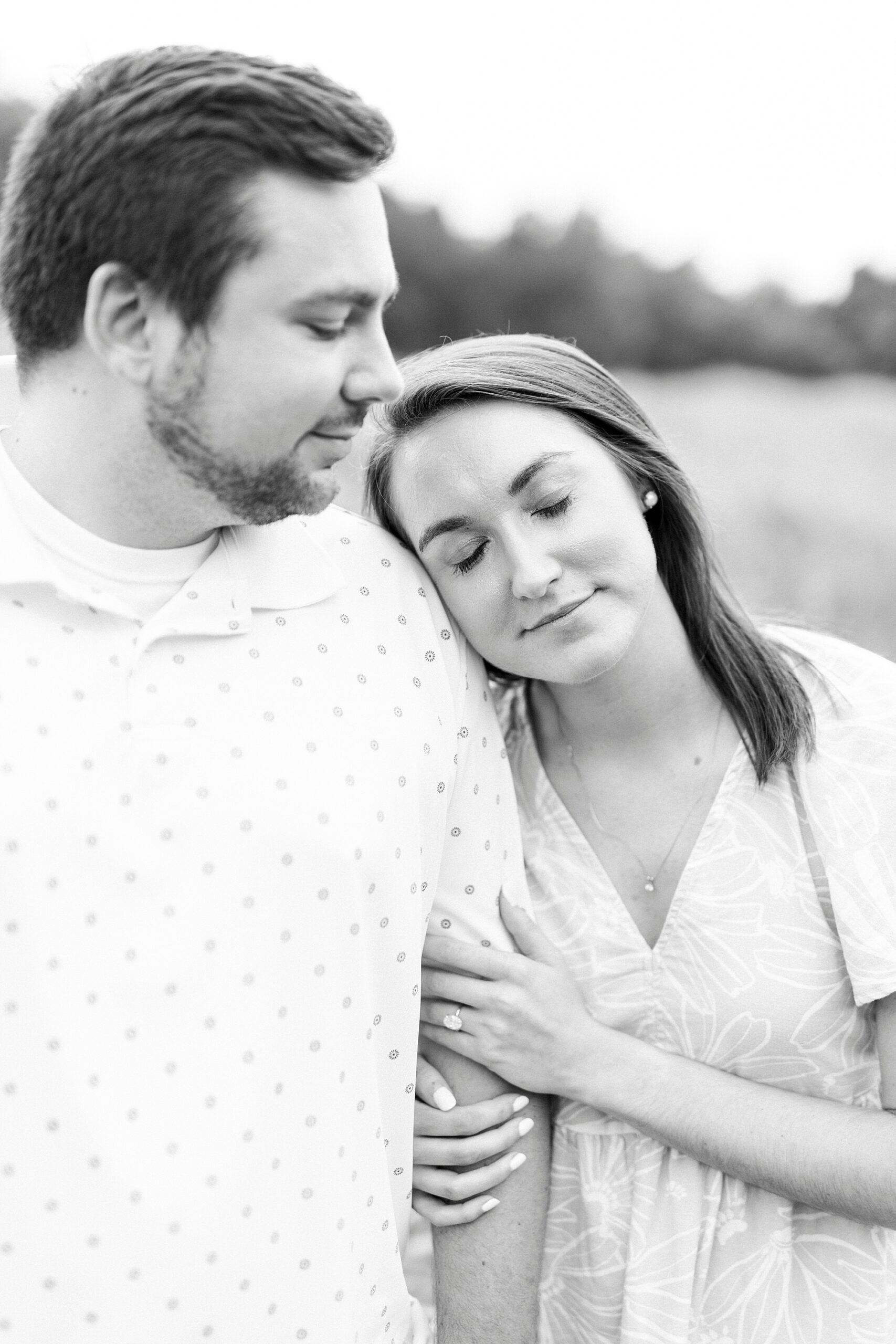 woman leans her head on man's shoulder during Kannapolis NC engagement session