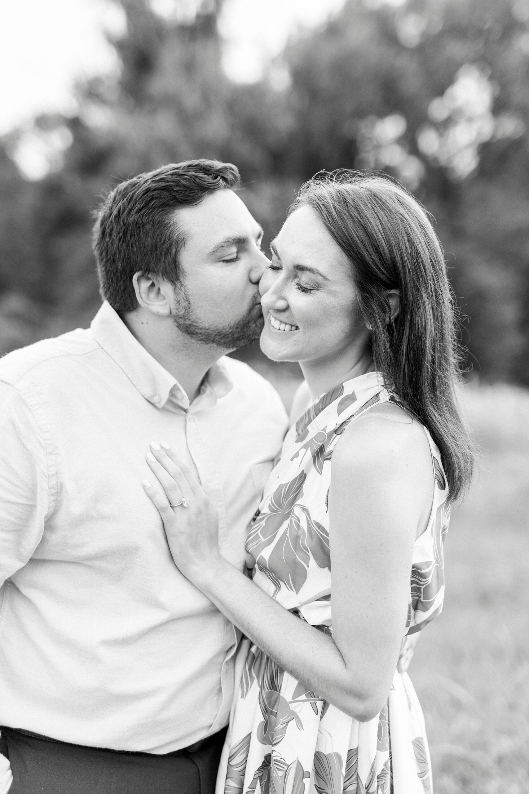 man kisses fiancee on the cheek during Kannapolis NC engagement session