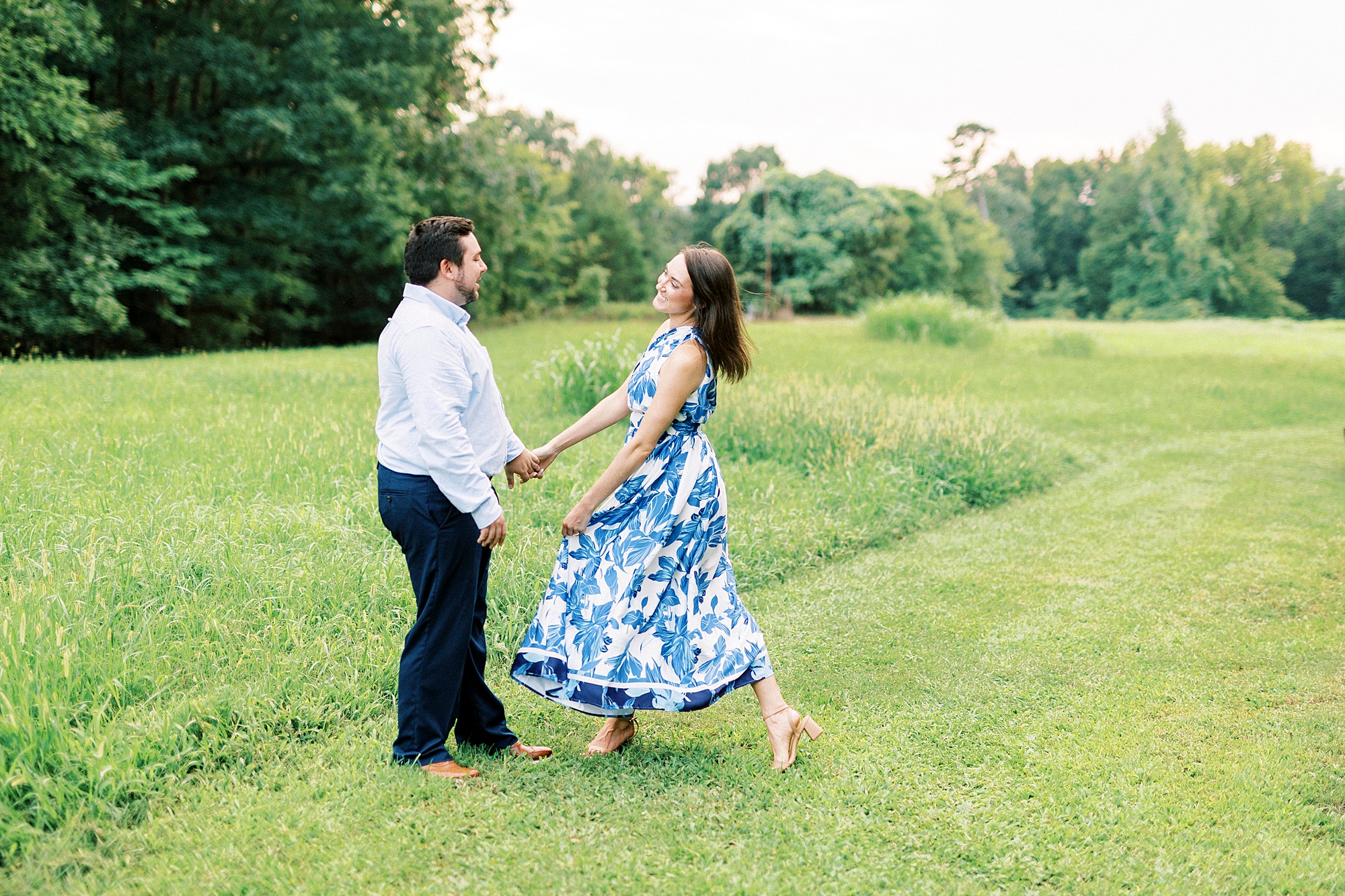 couple dances in field during Kannapolis NC engagement session