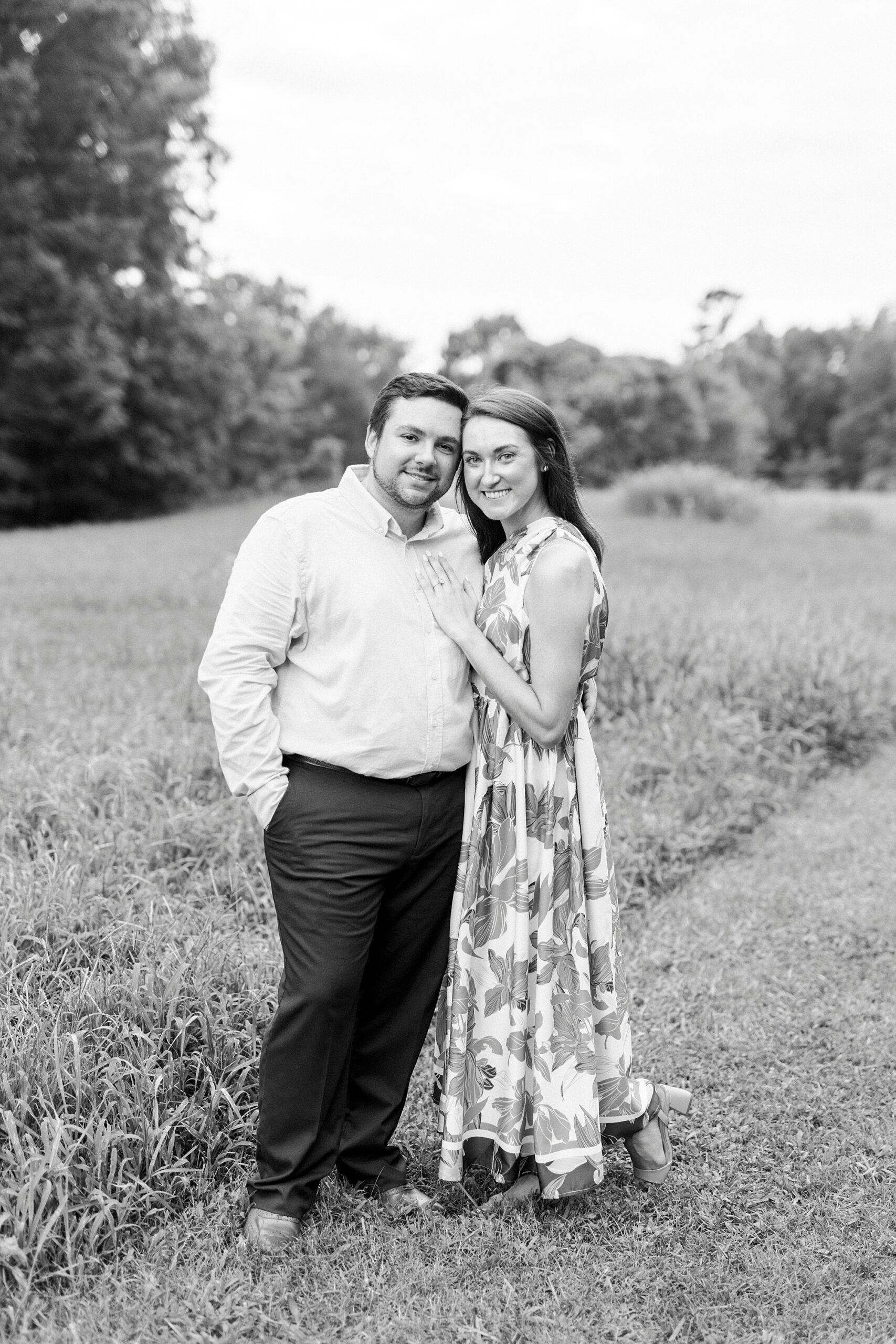 couple stands leaning heads together during engagement photos 
