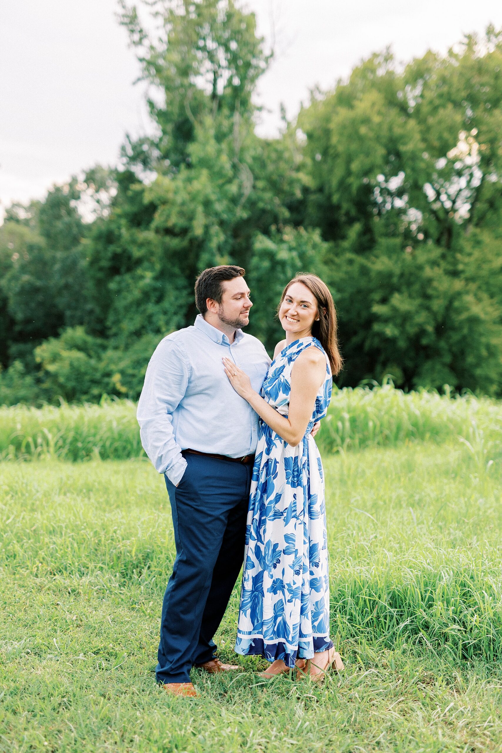 man smiles at woman standing in field in North Carolina 