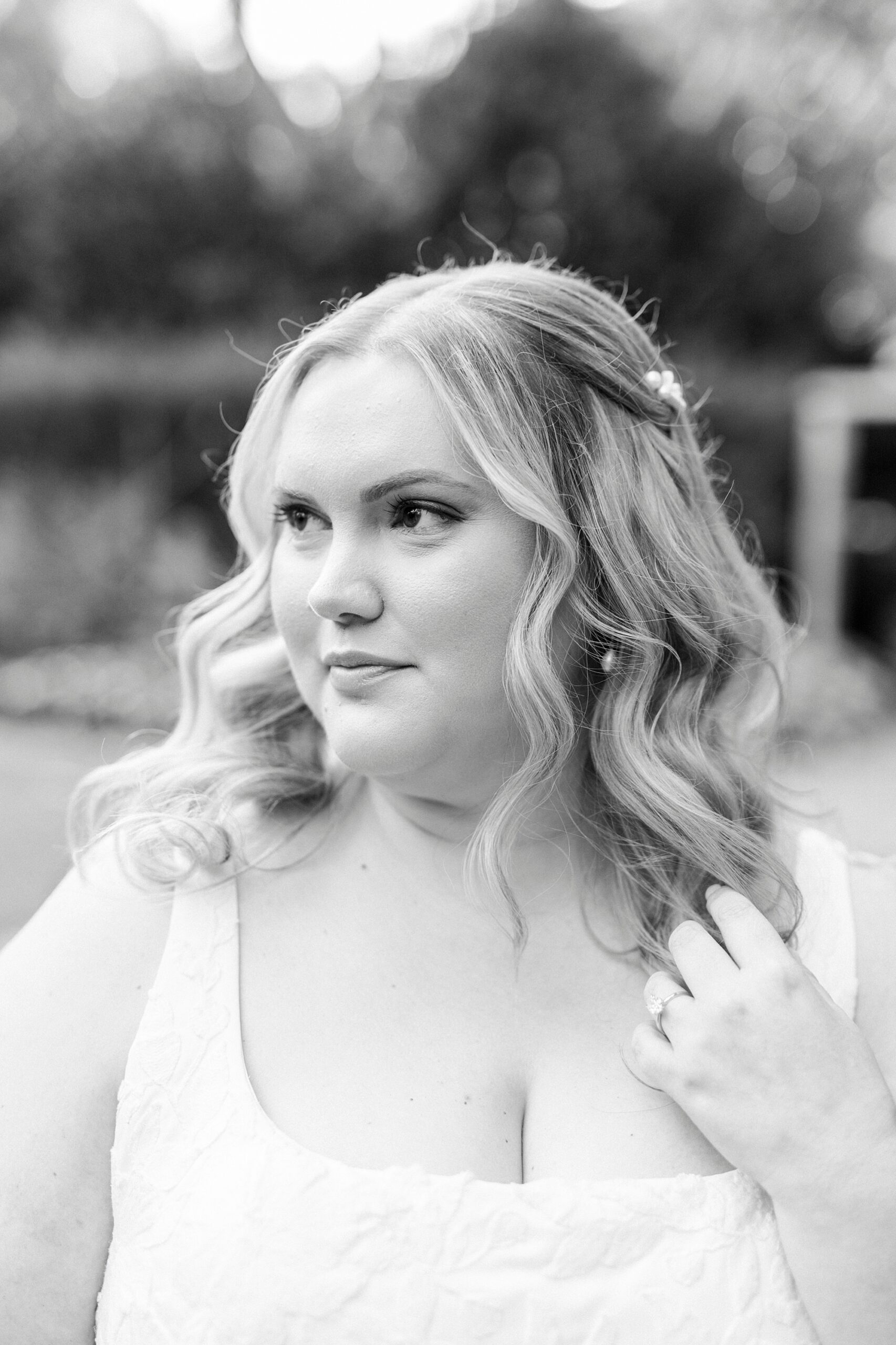 bride pulls hair off shoulder during bridal portraits 