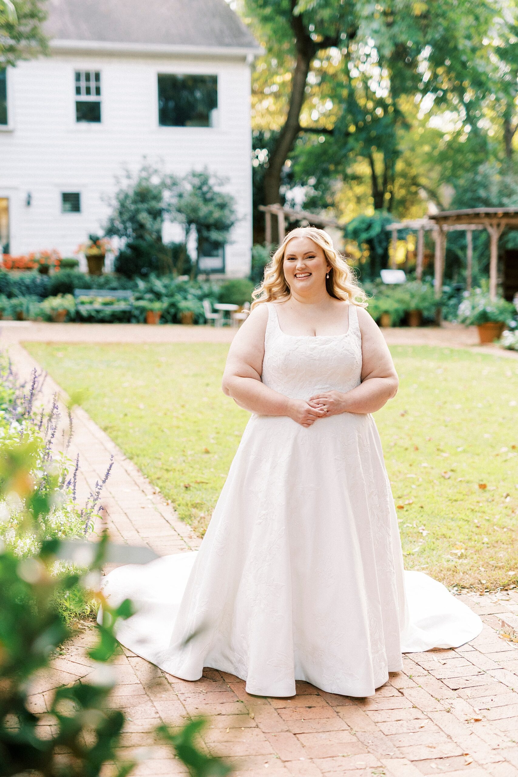 bride walks down brick pathway through Charlotte garden 
