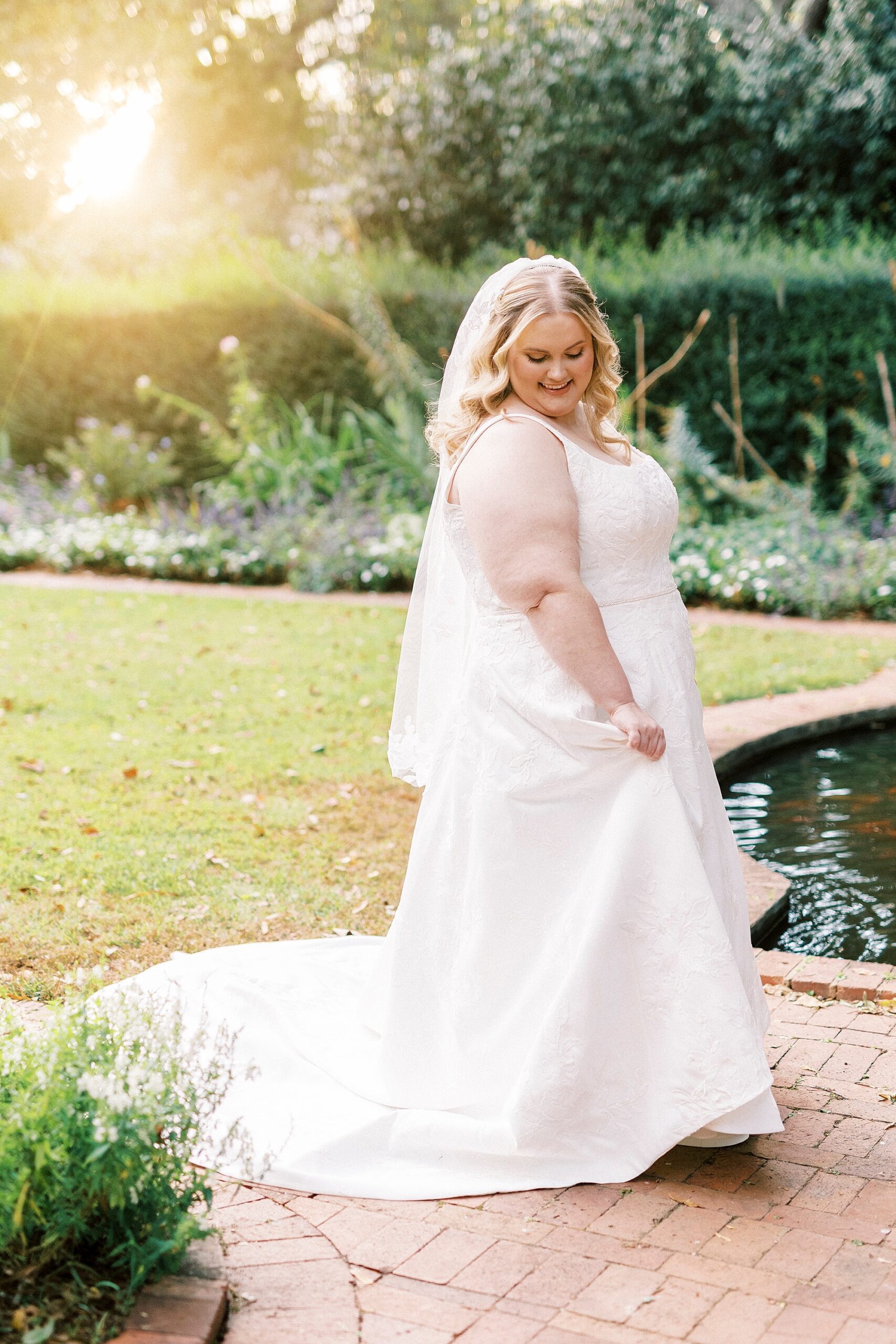bride twirls near pond inside Wing Haven Gardens