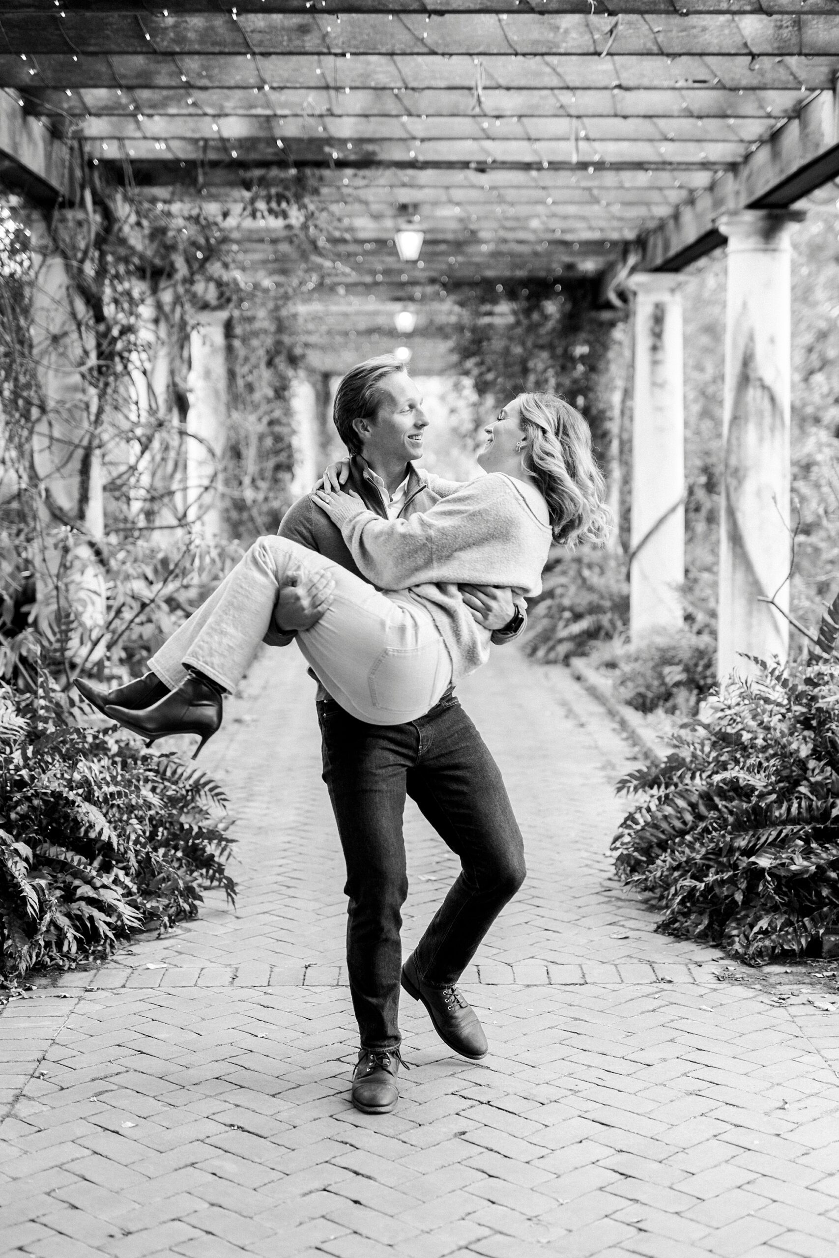 man carries woman through gardens n Charlotte NC