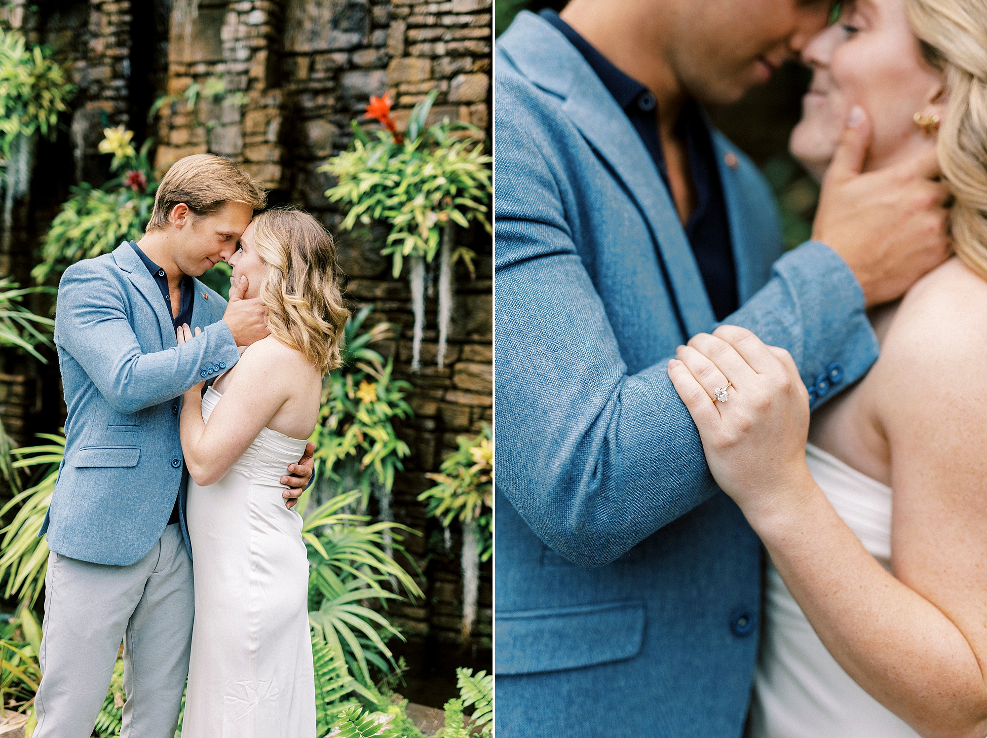 man in blue suit jacket holds woman's chin standing in front of stone wall