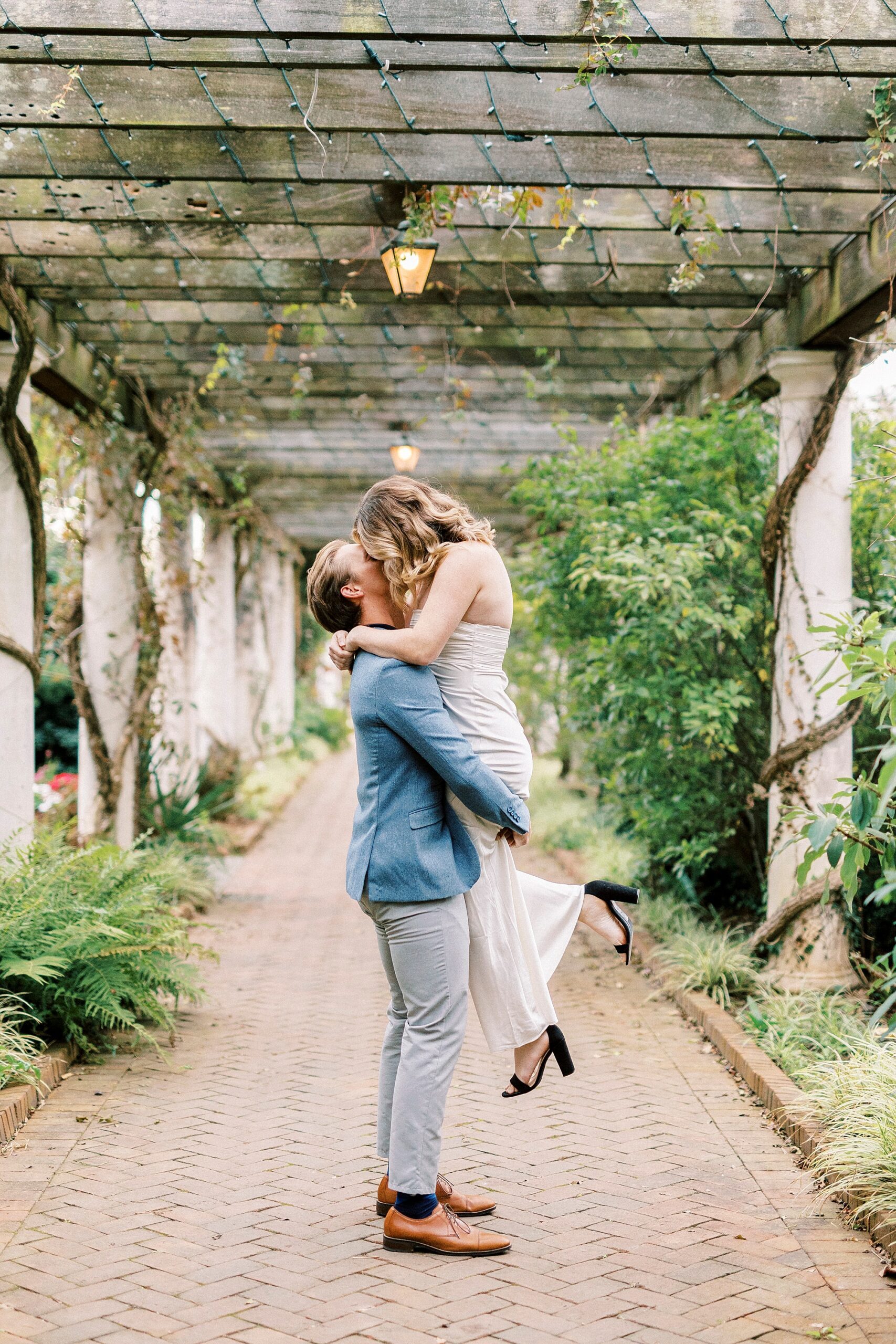 man lifts up woman on walkway at Daniel Stowe Botanical Garden