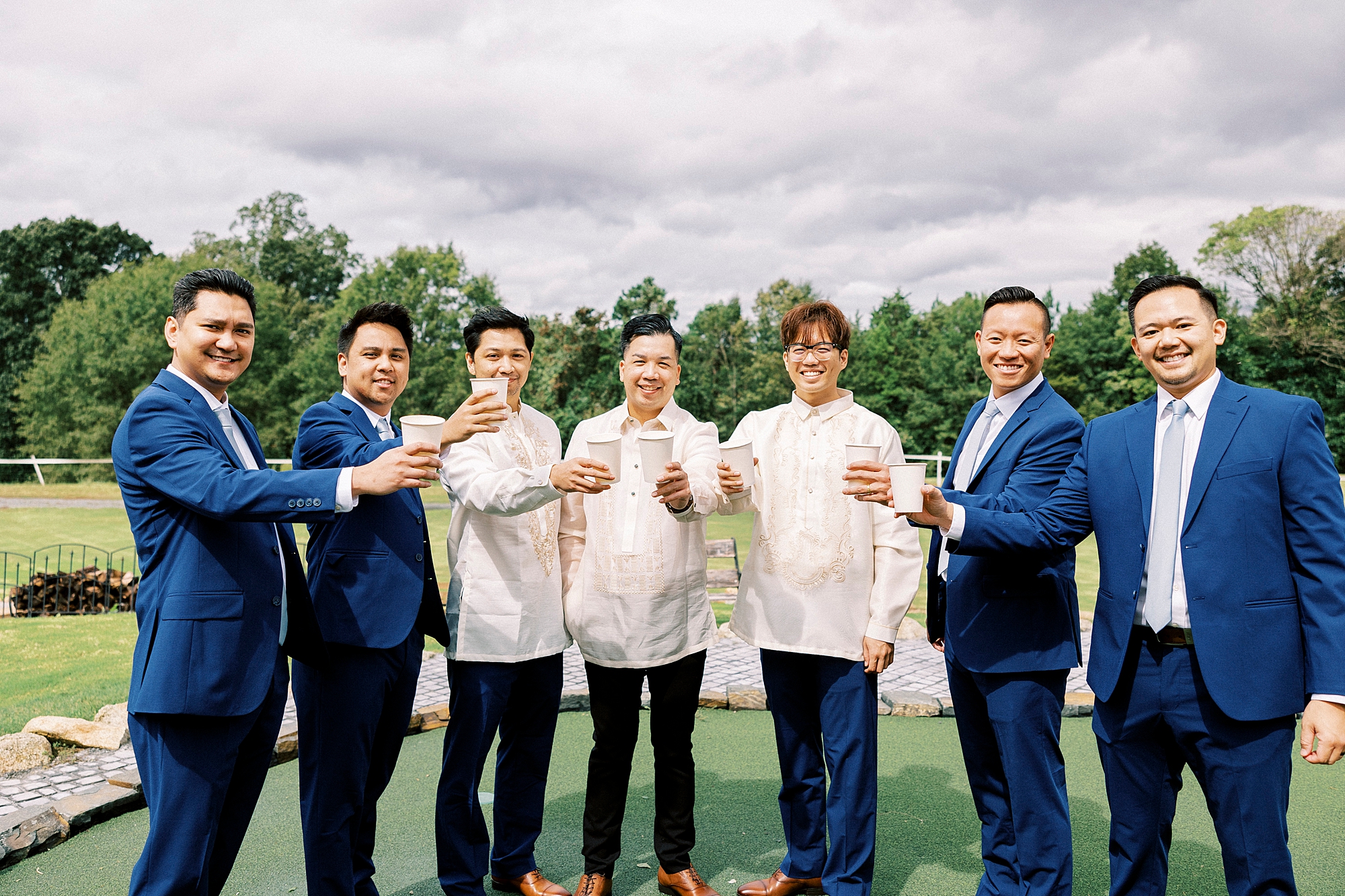 groom and groomsmen toast with drinks at Camelot Meadows