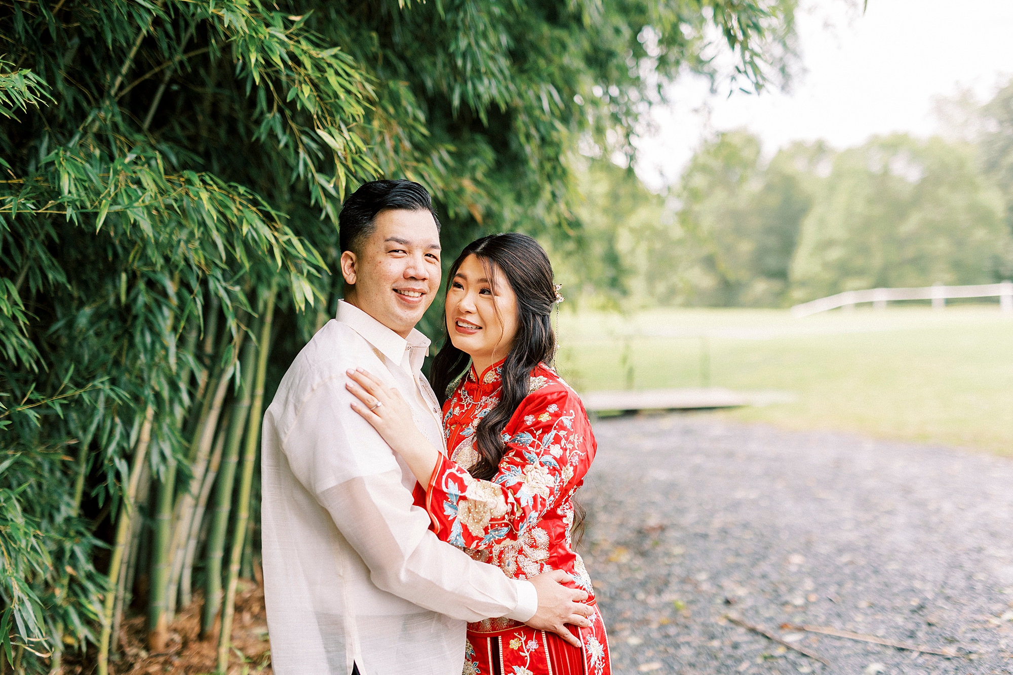bride and groom hug in traditional Chinese and Filipino wedding attire at Camelot Meadows