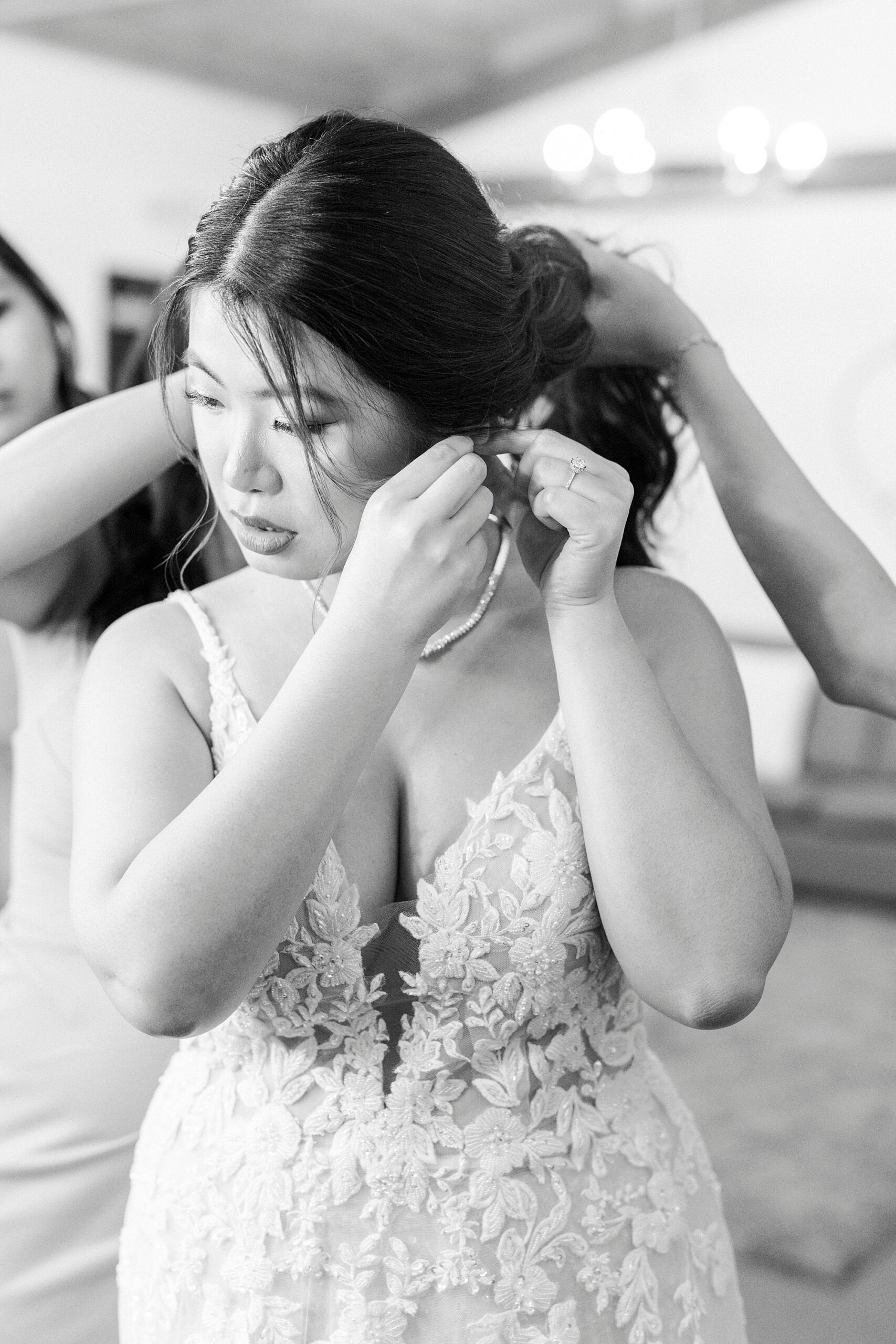 bride adjusts earrings in traditional wedding gown in Belmont NC