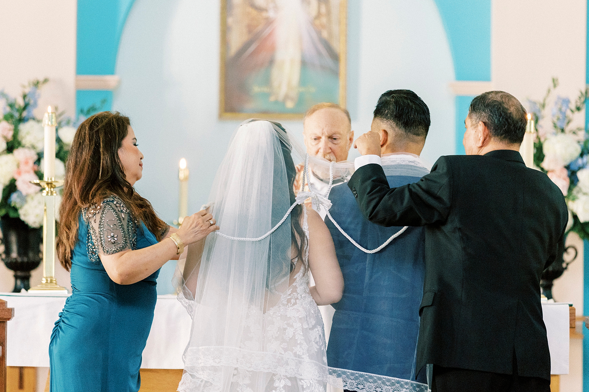 family members hug bride and groom during traditional wedding ceremony 