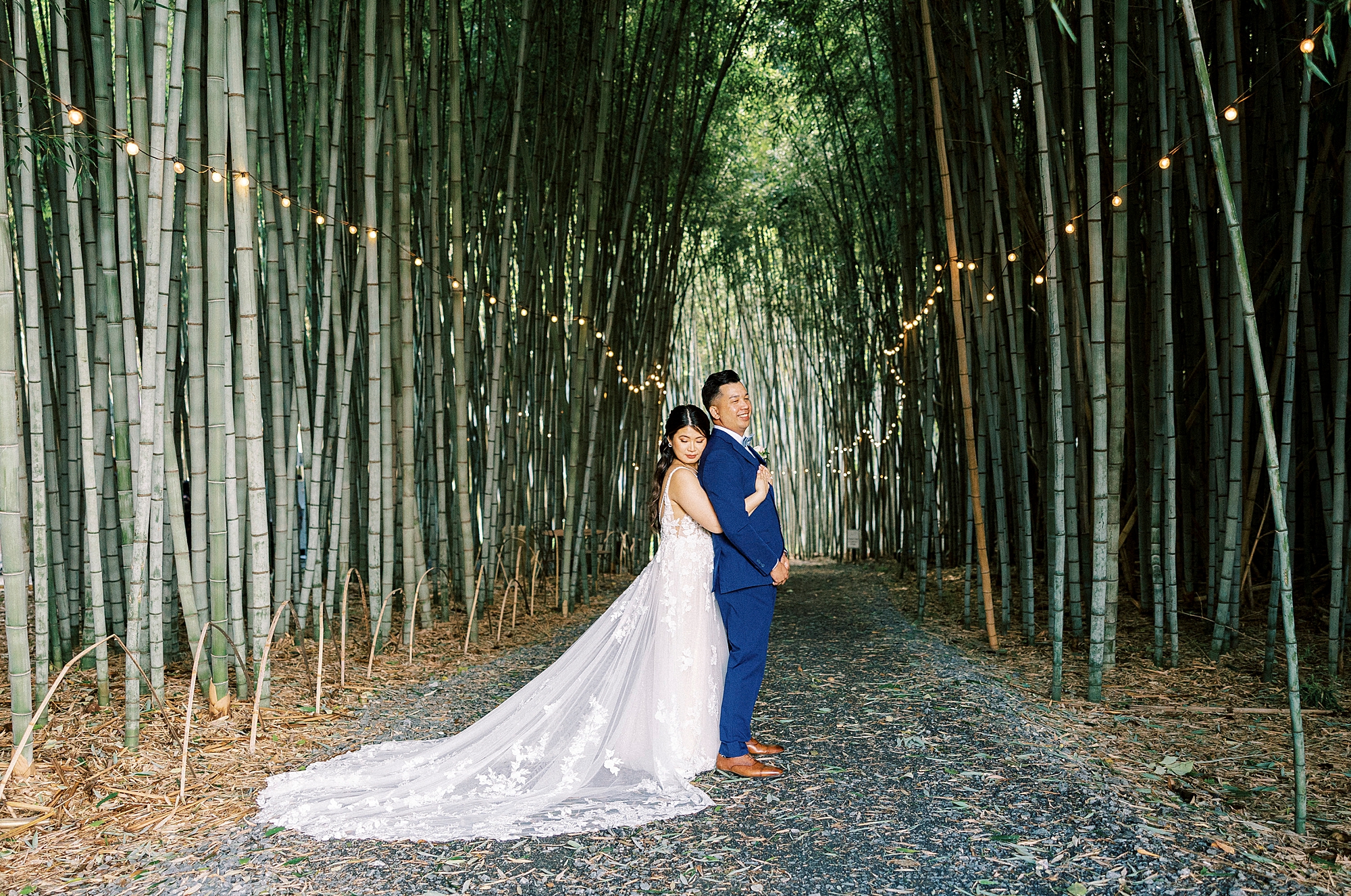 bride hugs groom from behind inside bamboo forest at Camelot Meadows