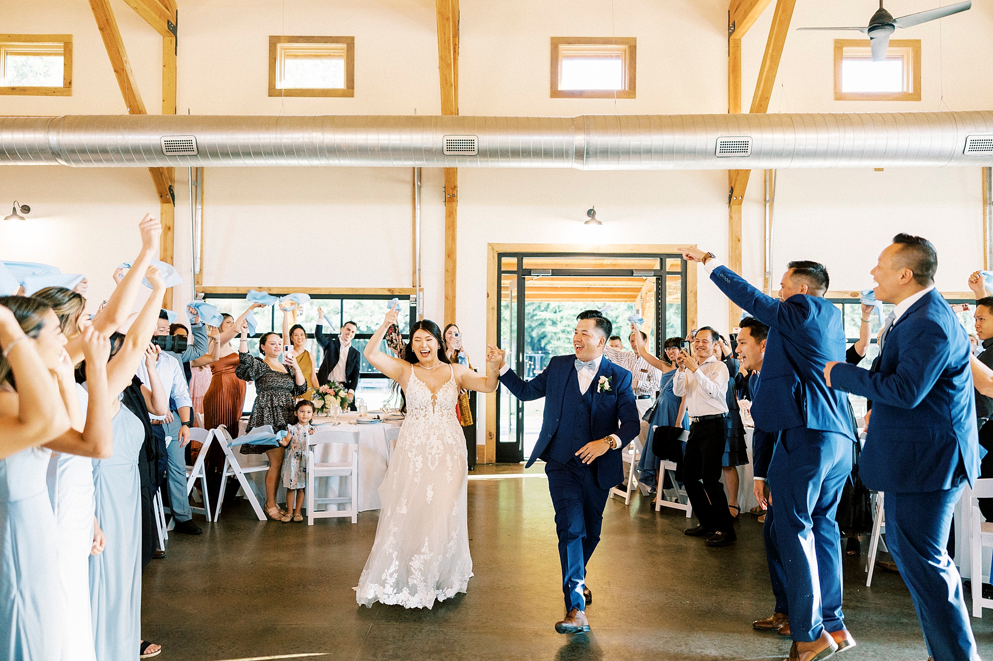 newlyweds cheer walking into reception at Camelot Meadows