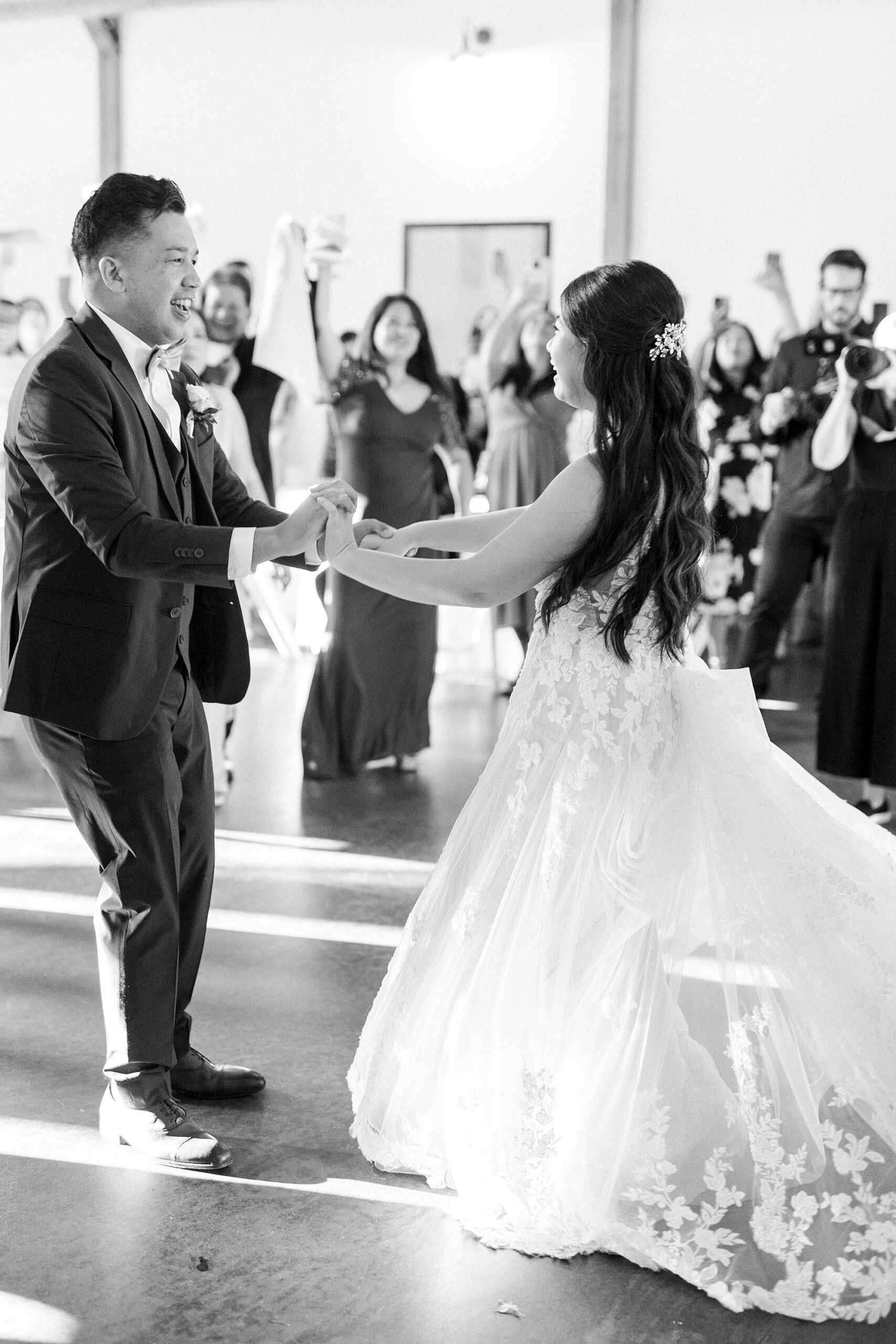 bride and groom hold hands twirling on dance floor
