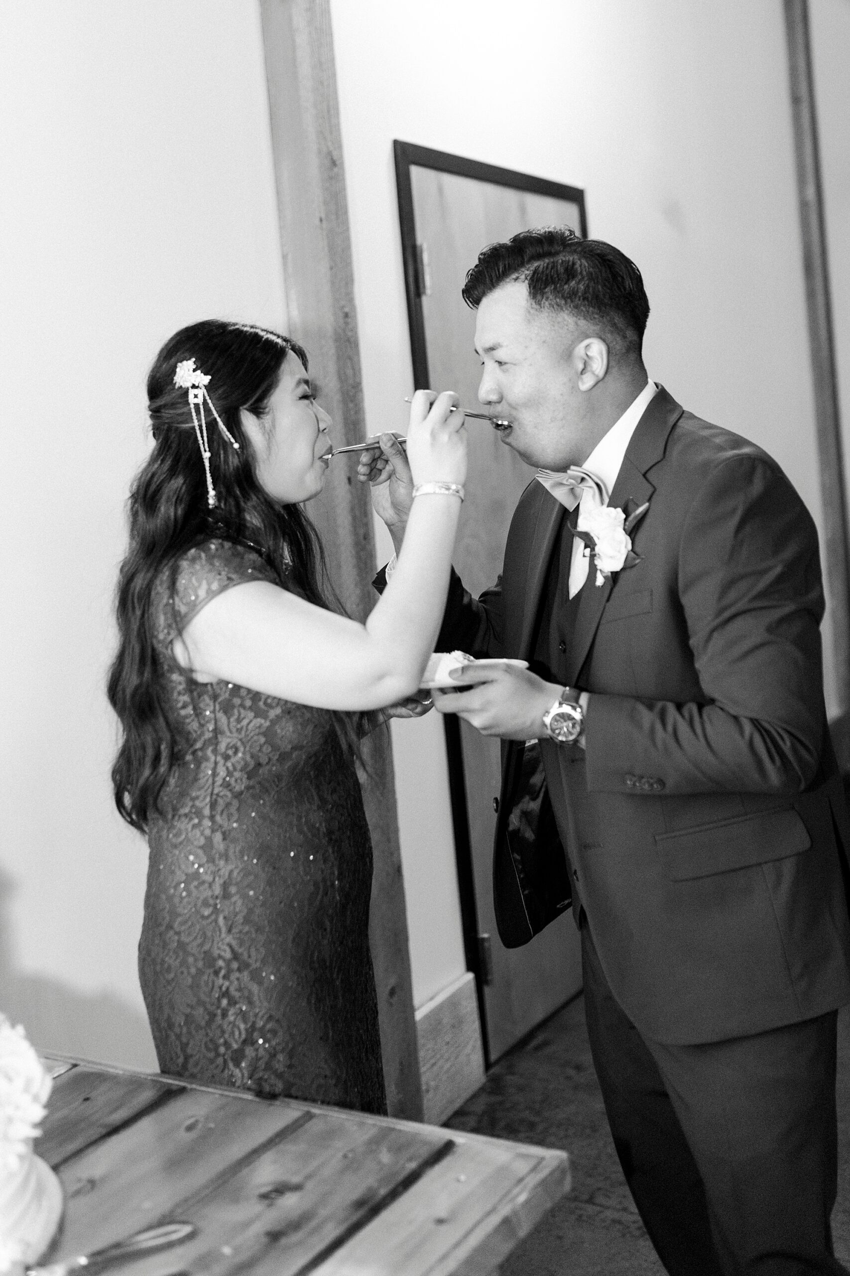 bride and groom feed each other cake inside Camelot Meadows