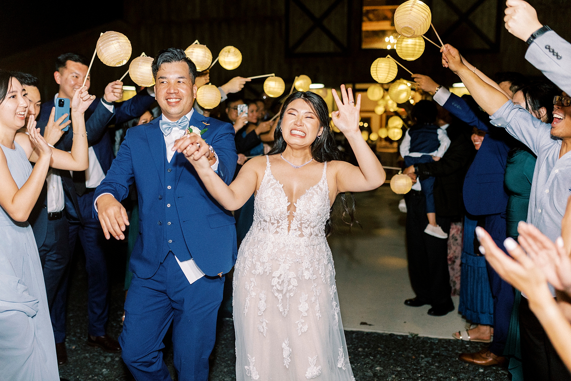 bride and groom kiss leaving Camelot Meadows with traditional lanterns around them