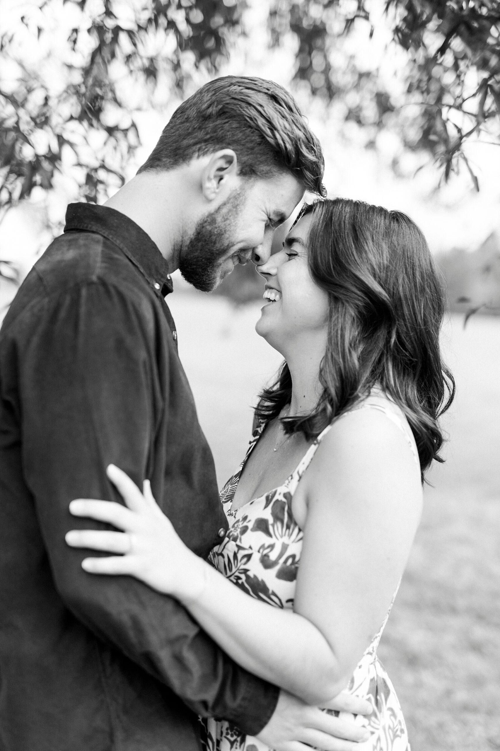engaged couple hugs leaning heads together during photos