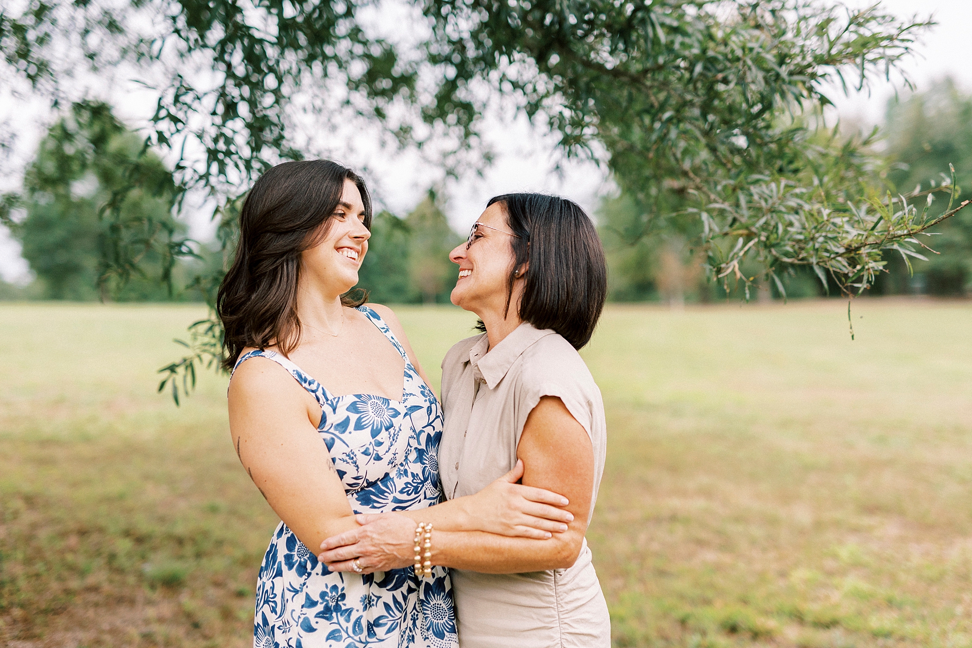 mom and daughter hug leaning back to smile at each other
