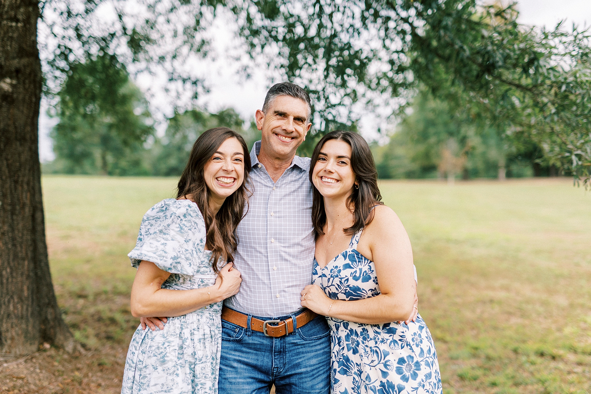 dad hugs two daughter during family photos in Rob Wallace Park