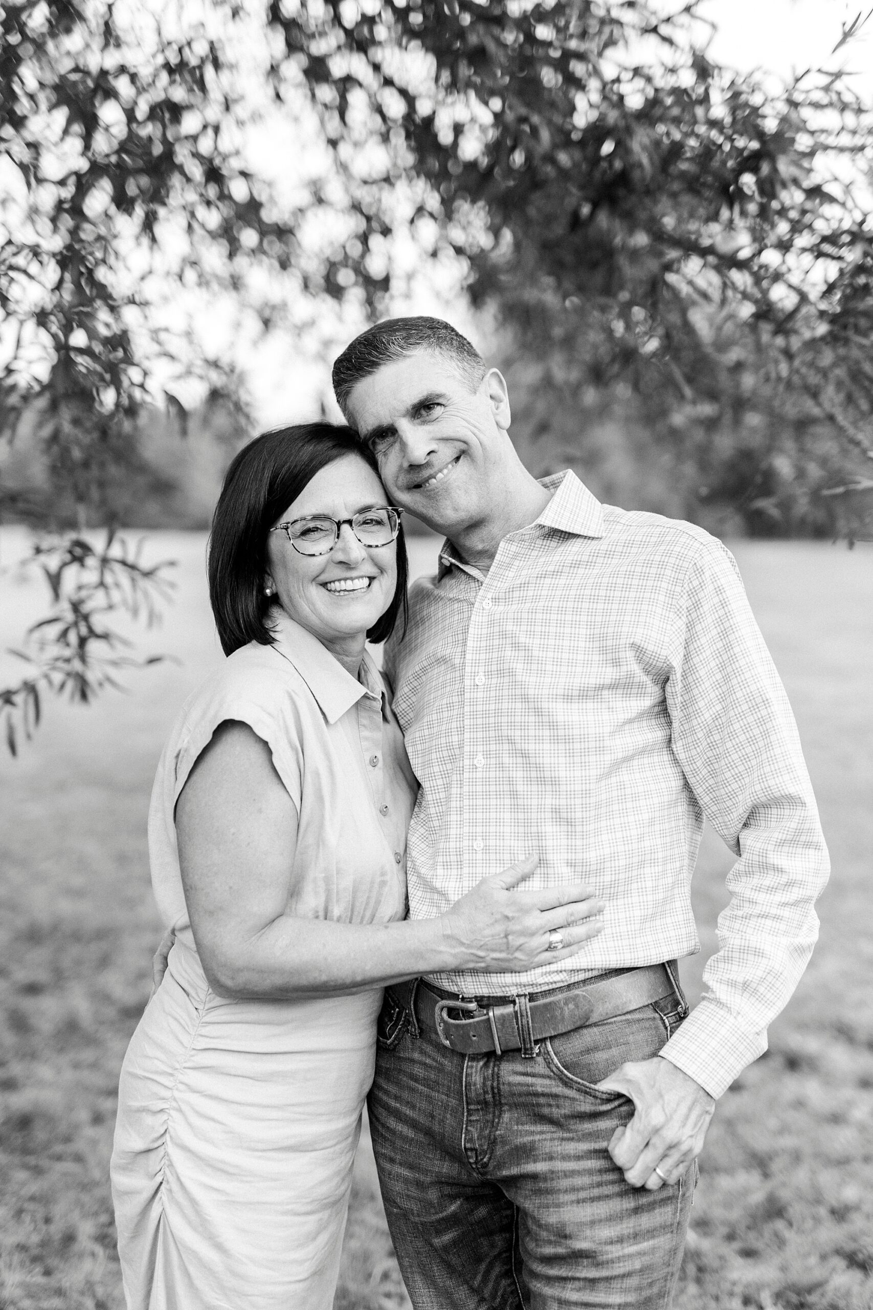 husband and wife hug during family photos