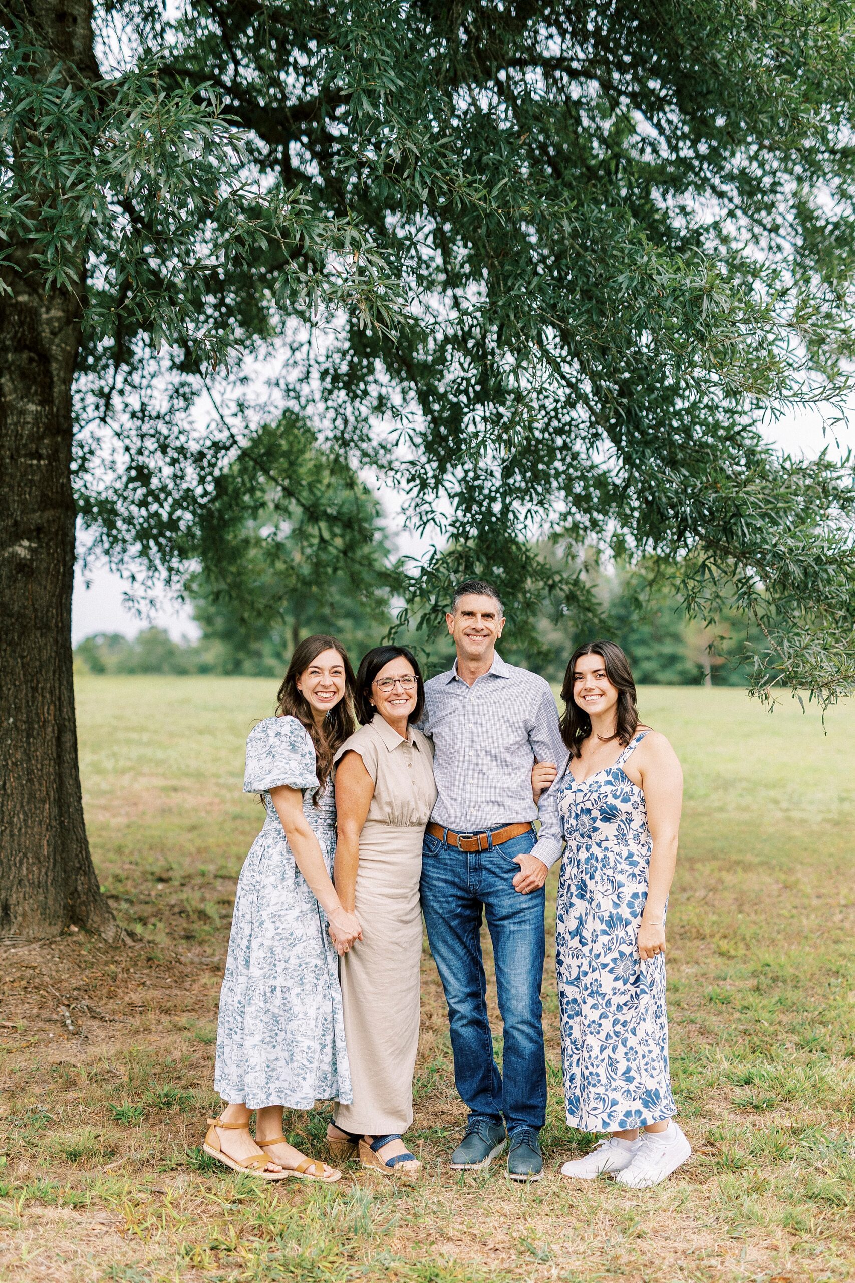 parents stand with adult daughters during family photos