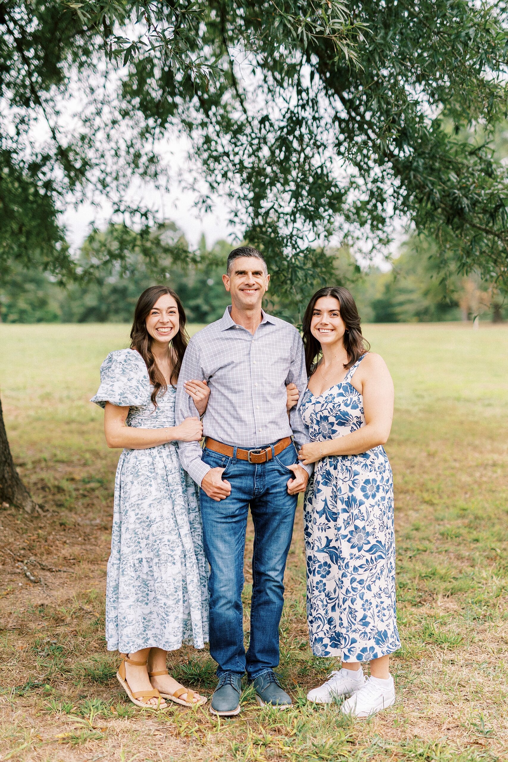 dad stands with two daughters during fall family photos